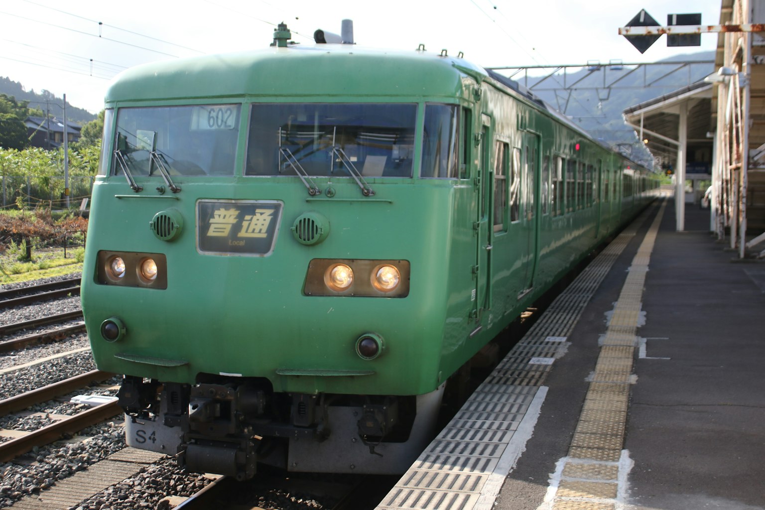 Green train arriving at a station