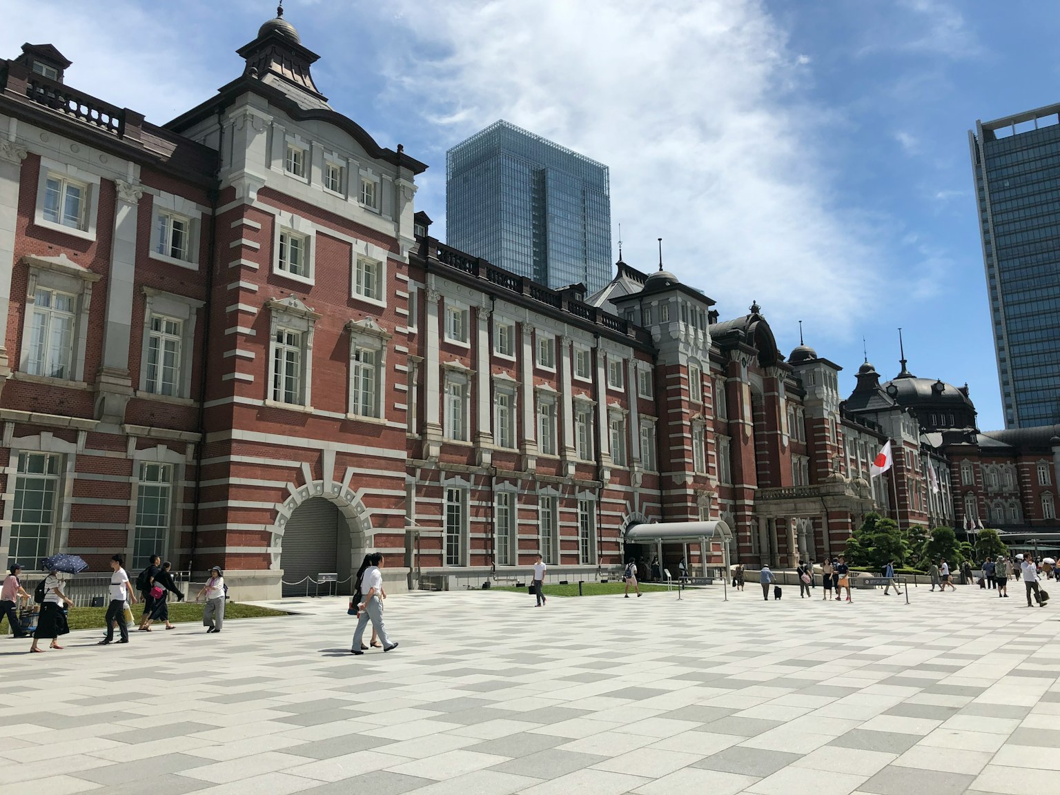 Architecture historique de la gare de Tokyo avec des bâtiments modernes en arrière-plan