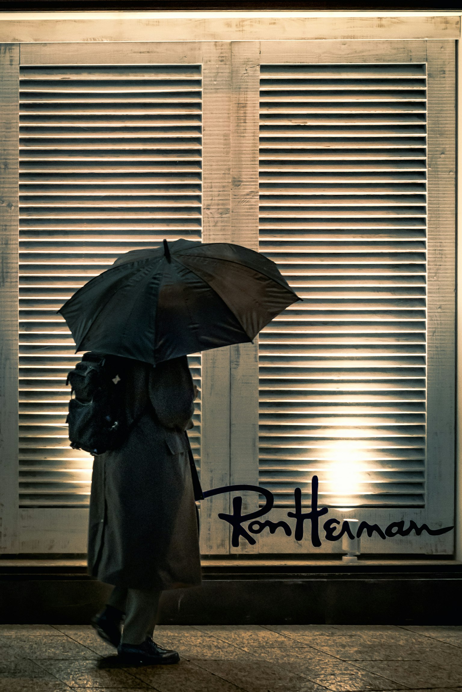 Người đang đi với ô dưới nền Ron Herman