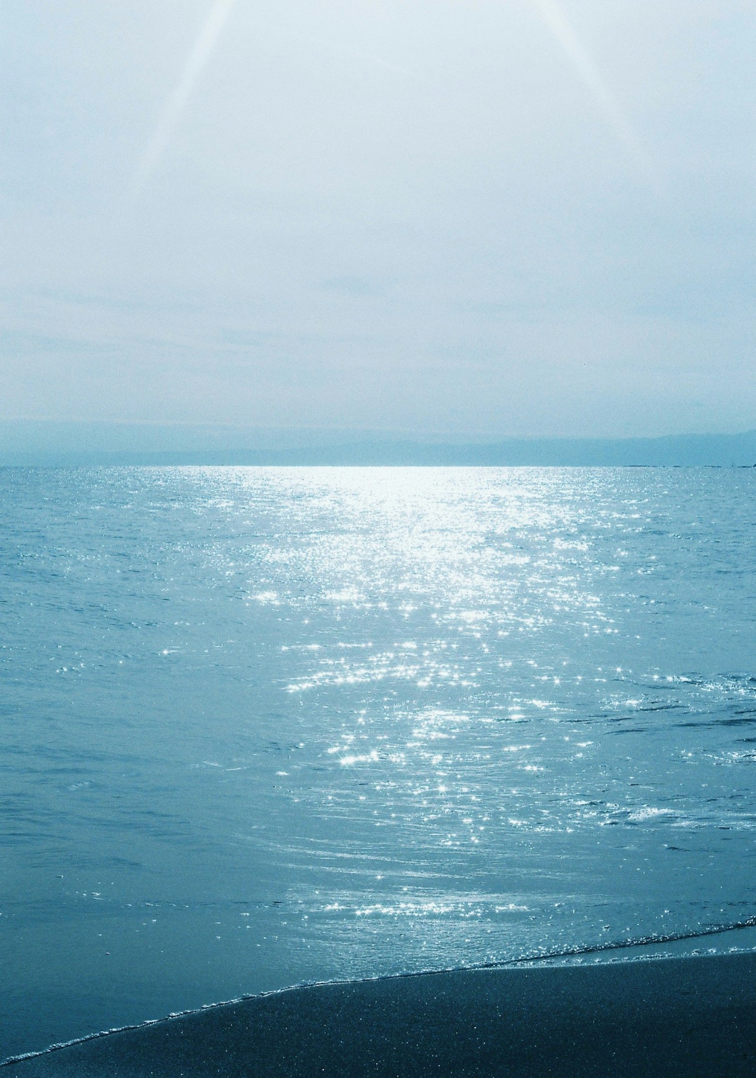 Oceano calmo con luce scintillante sulla superficie d'acqua blu