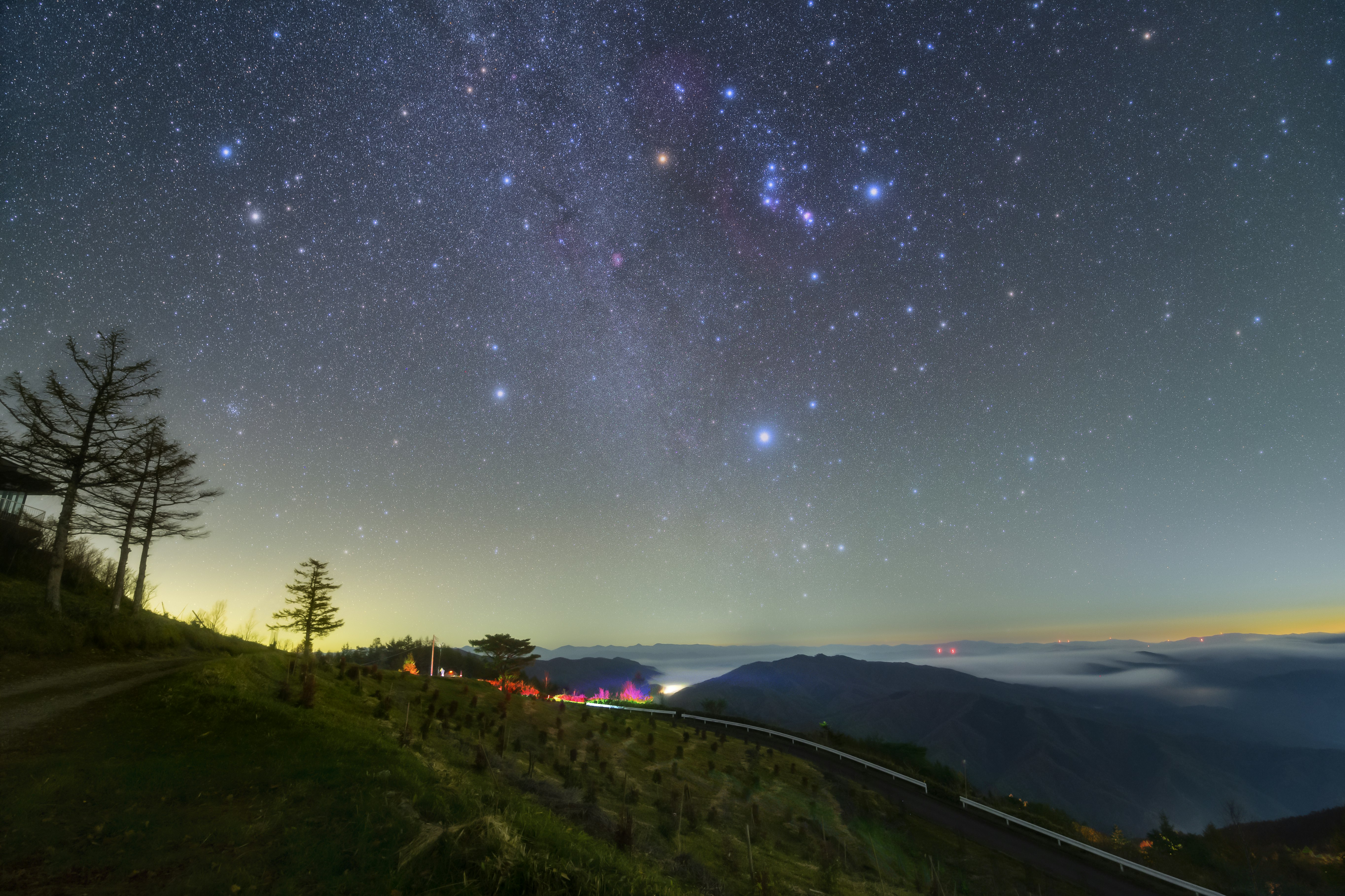 夜空に広がる星と山並みを見下ろす稜線の風景