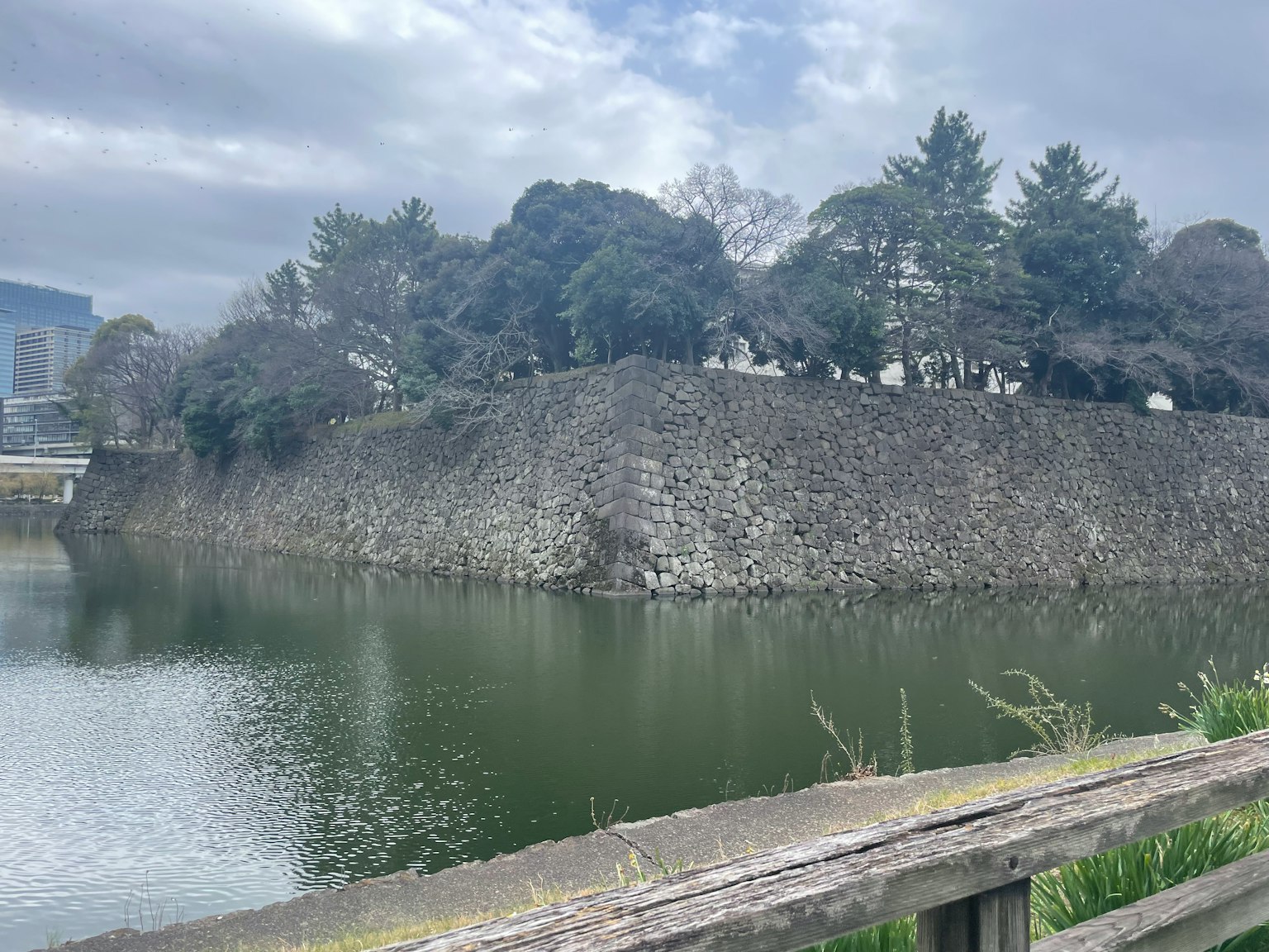 Landschaft mit einer Steinmauer und reflektierender Wasseroberfläche