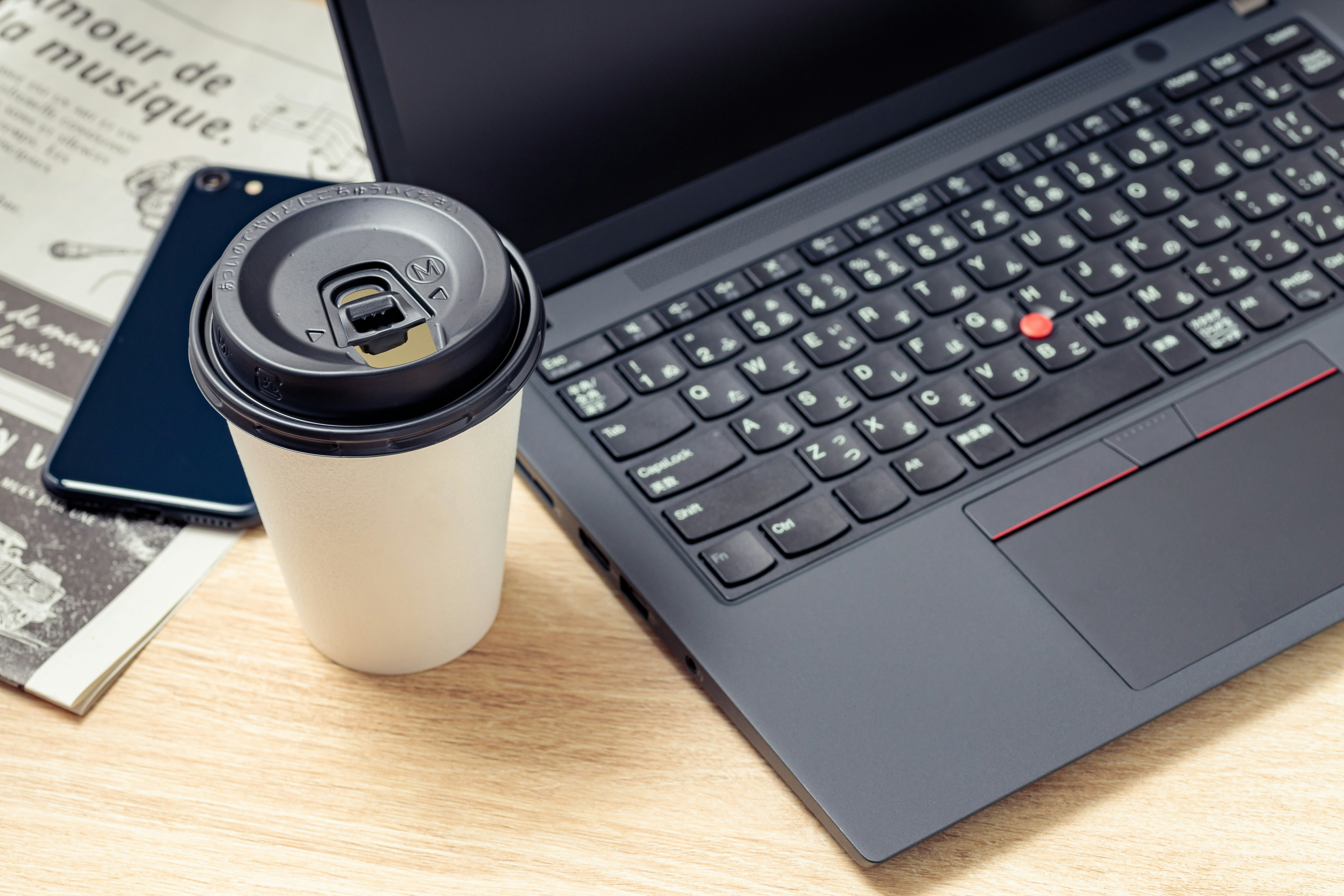 ノートPCとコーヒー、新聞のあるビジネスデスク