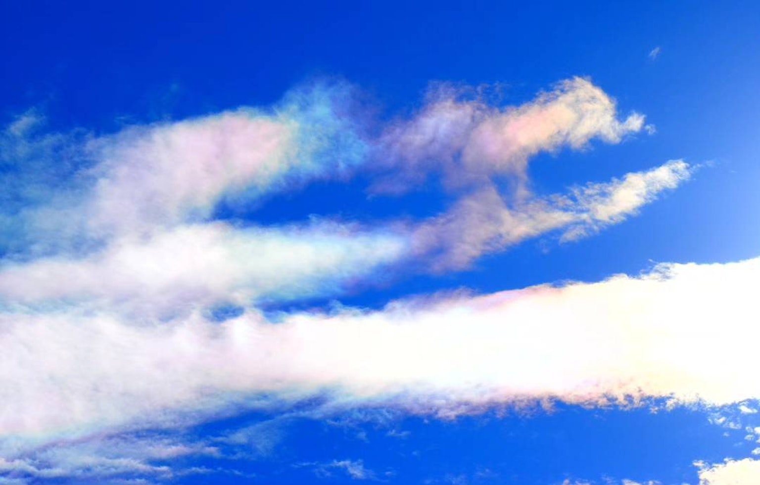 Irideszente Wolken in einem hellblauen Himmel
