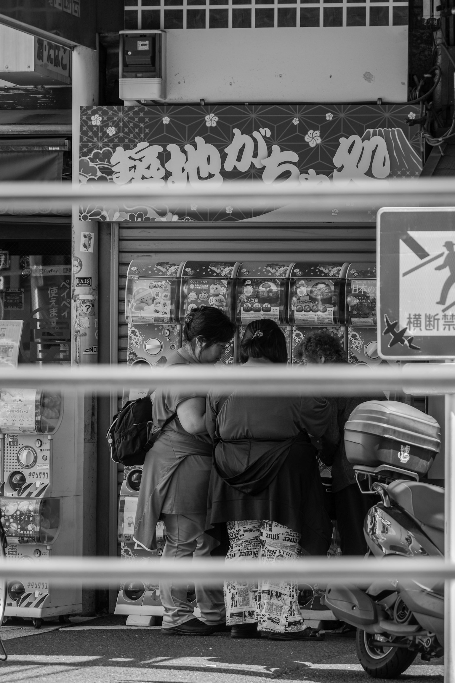 People selecting products at a street corner store in black and white
