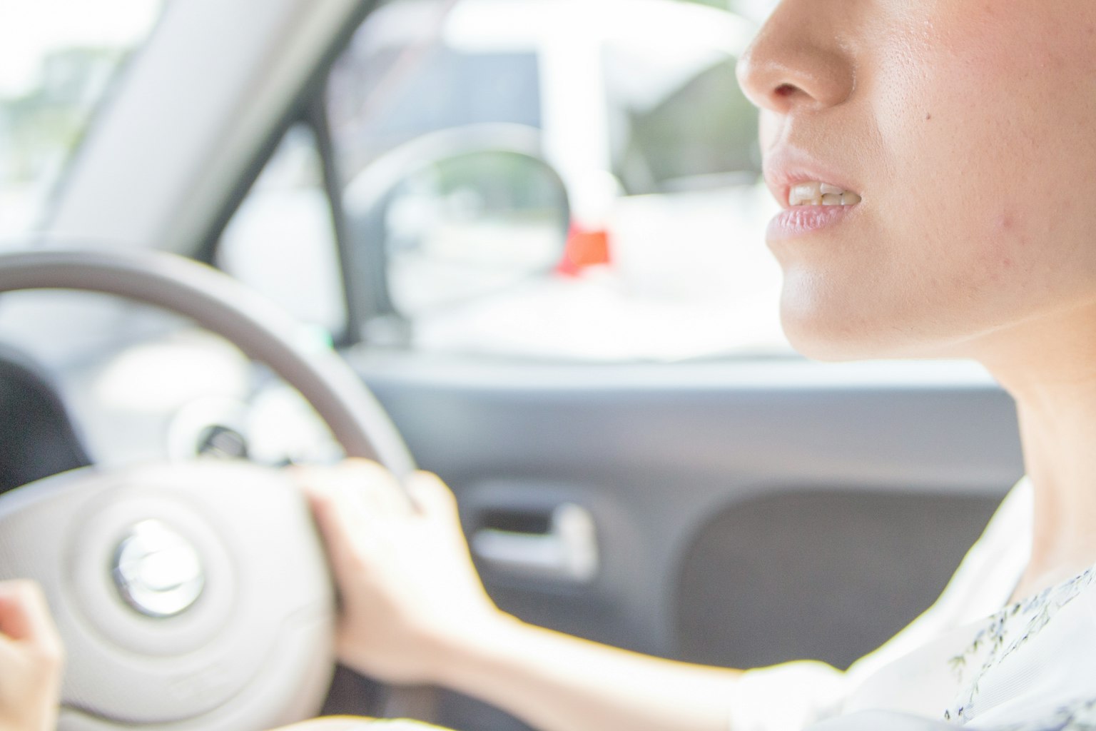 Primer plano del rostro de una mujer conduciendo sosteniendo el volante