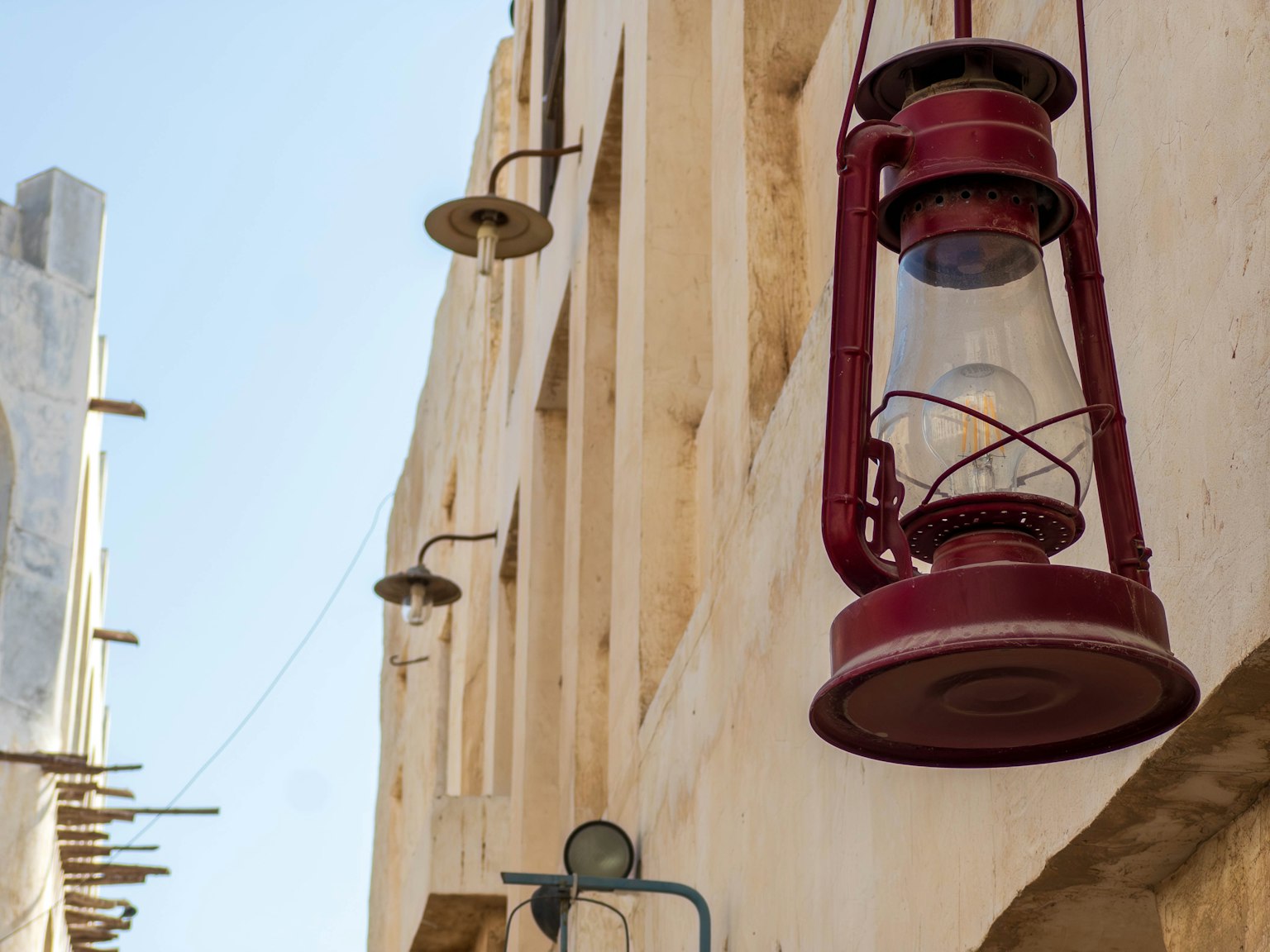 Linterna roja colgando de la pared de un edificio antiguo