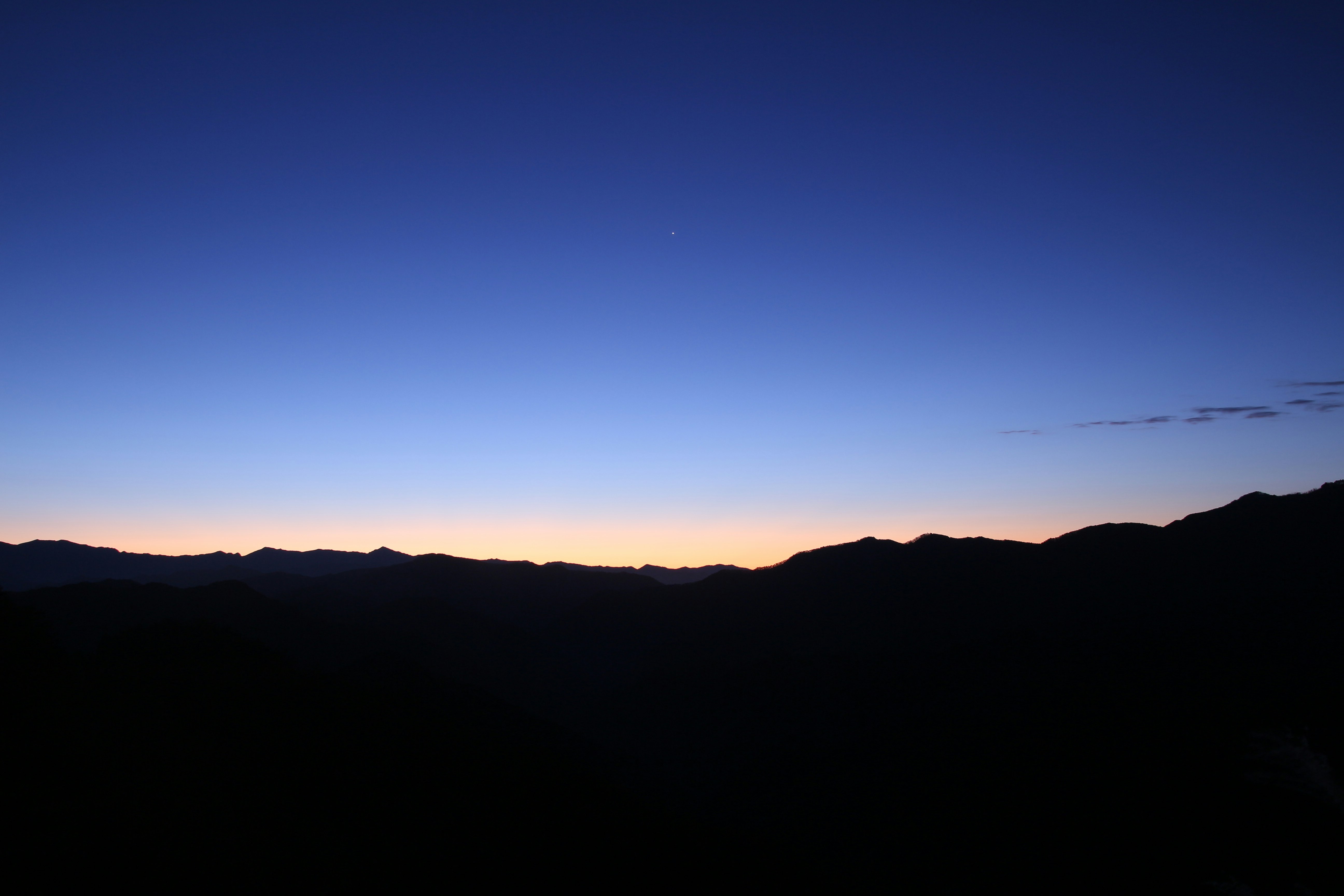 paisaje de cordillera montañosa al atardecer bajo un cielo azul