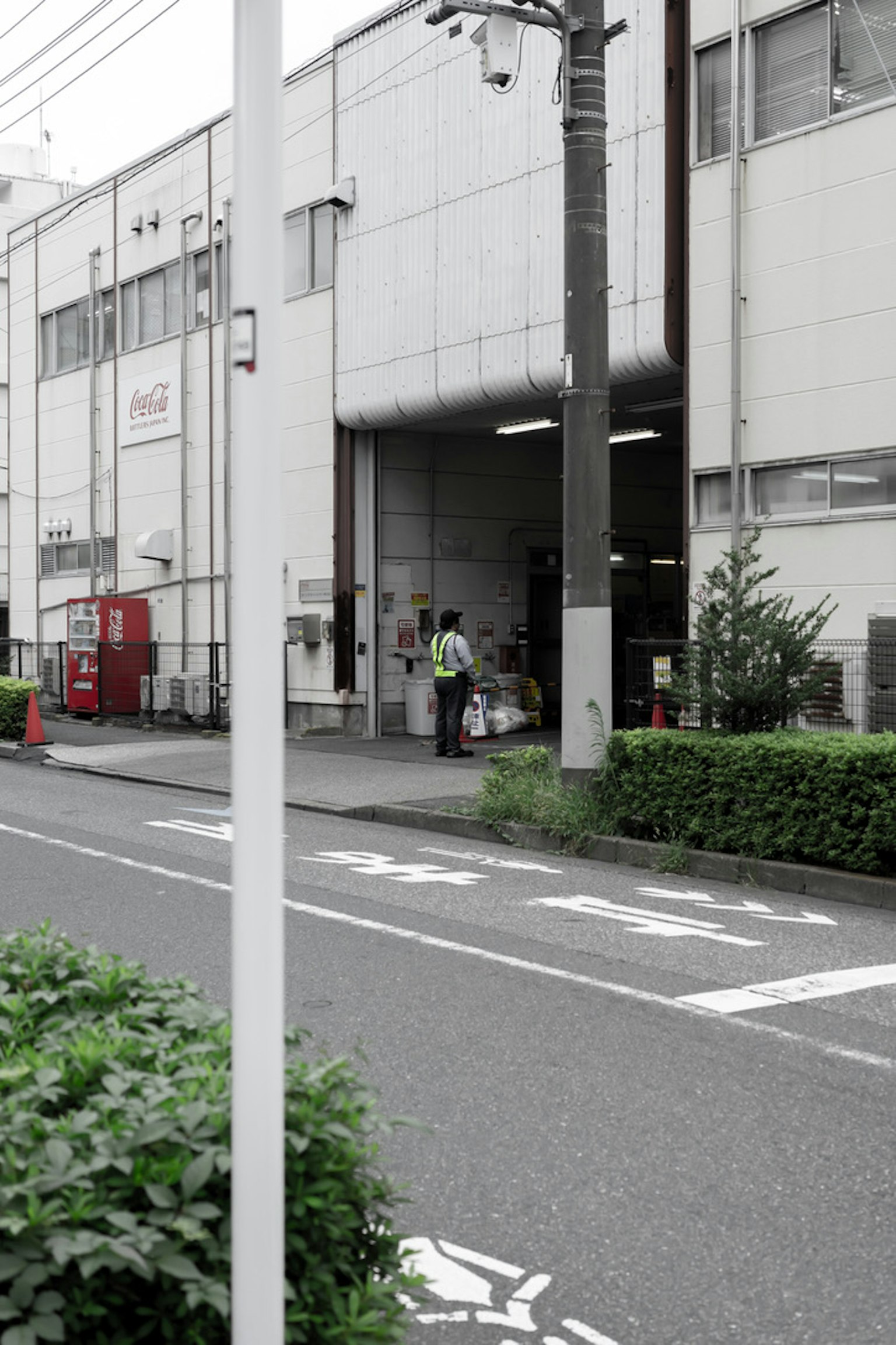 Travailleur à l'extérieur d'une usine avec de la verdure à proximité