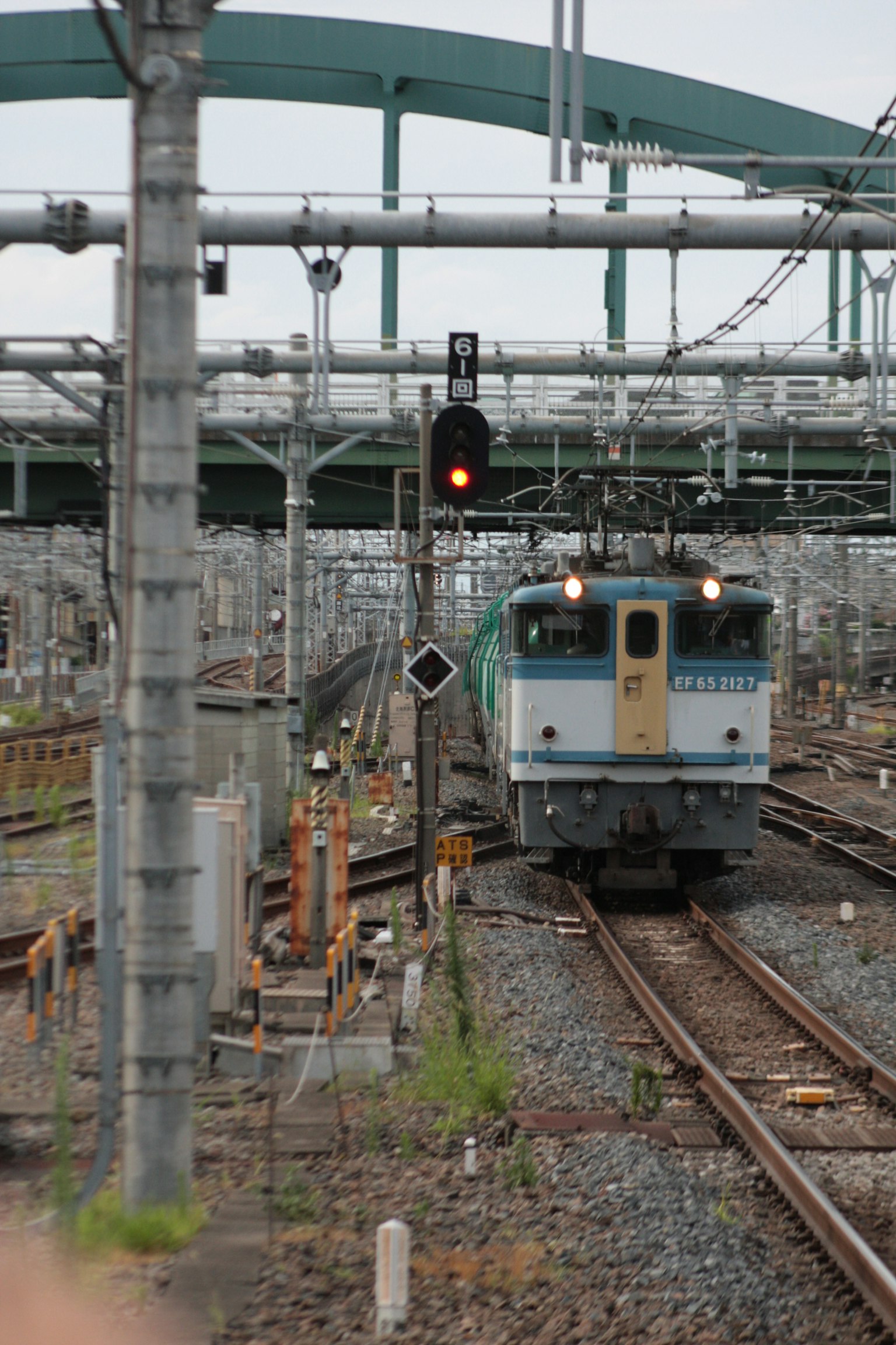 Kereta biru dan putih mendekat di rel hijau