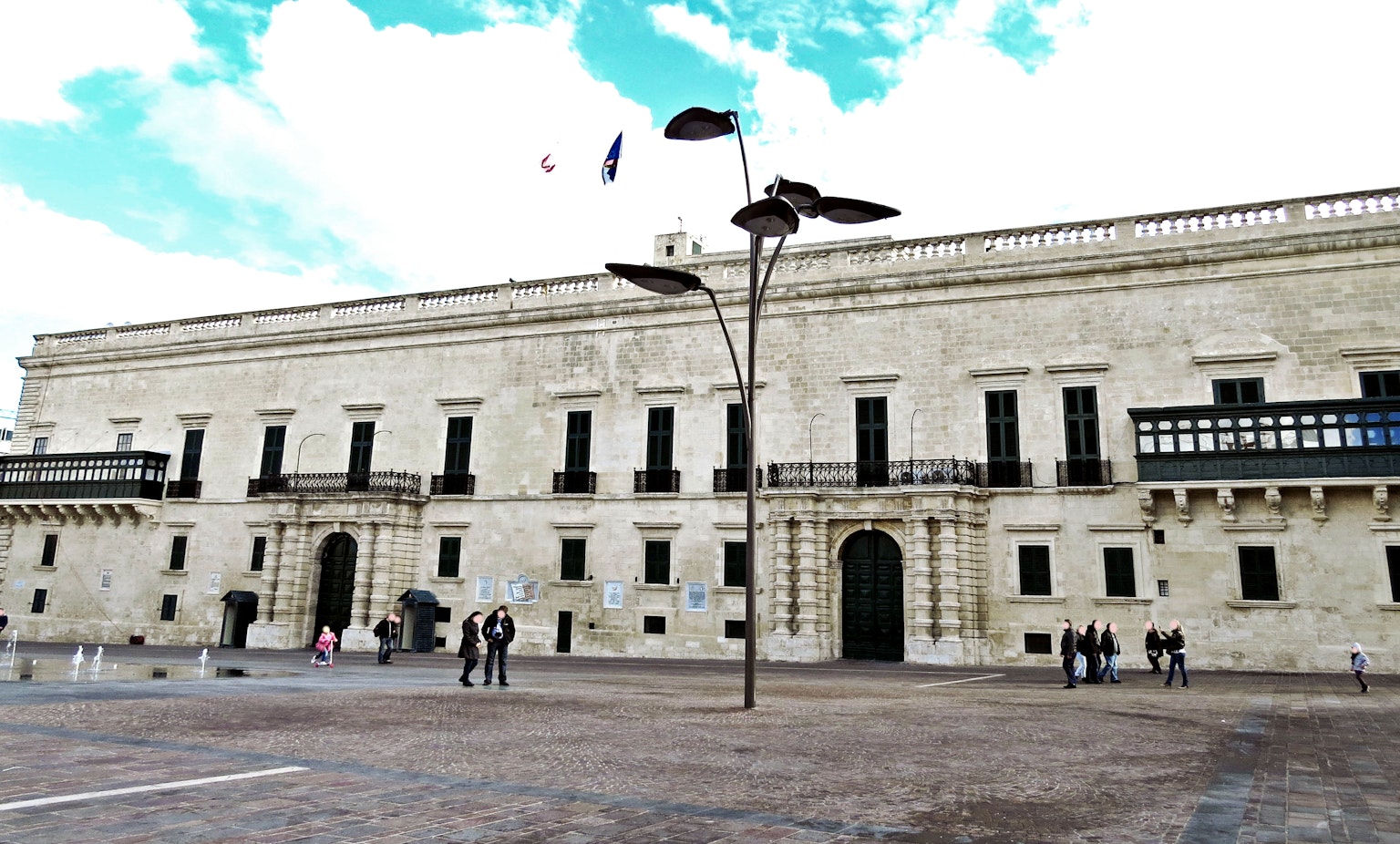 Façade d'un bâtiment historique donnant sur une place avec ciel bleu