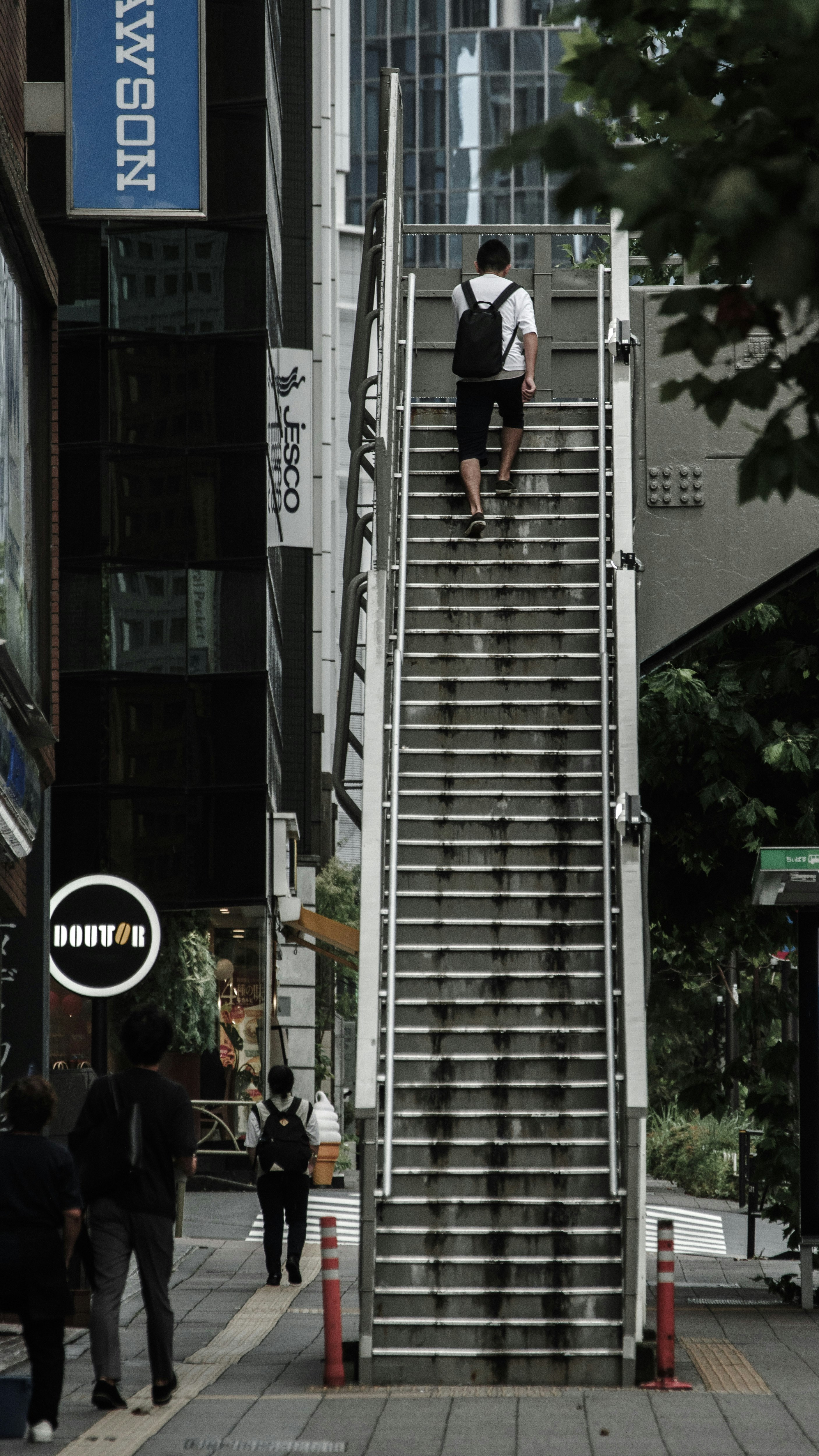 青山通りの歩道橋に続く階段の都市風景