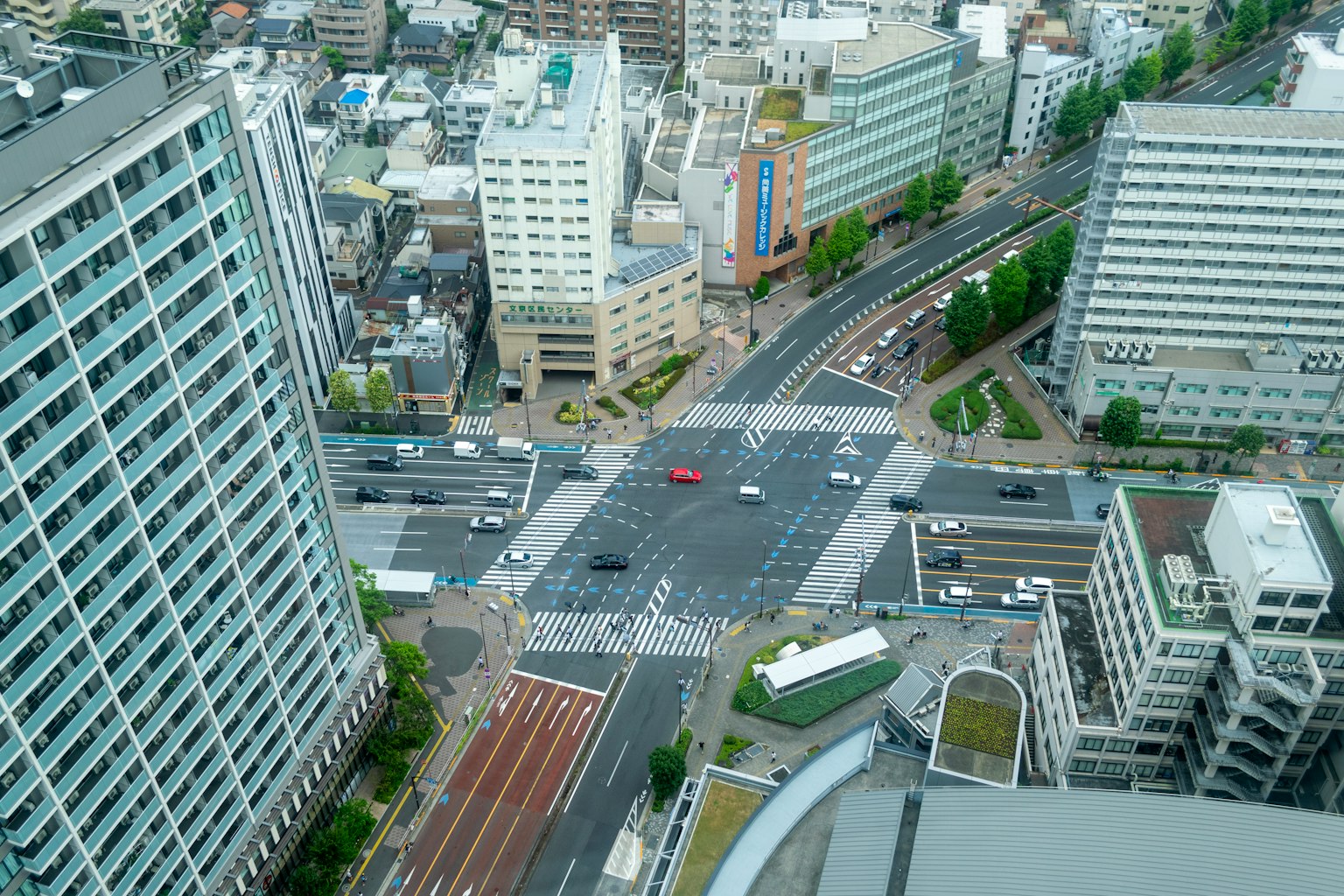 Aerial view of a cityscape featuring an intersection and vehicles