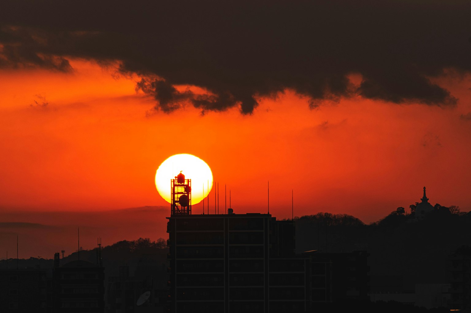 Silhouette kota dengan matahari terbenam dan langit oranye