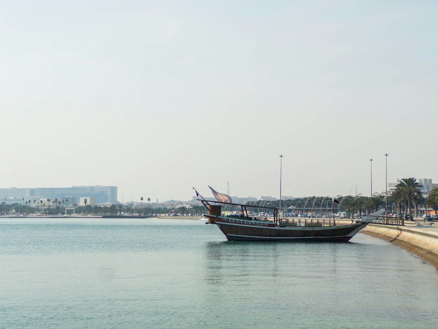 Perahu tradisional berlabuh di perairan tenang dekat pantai