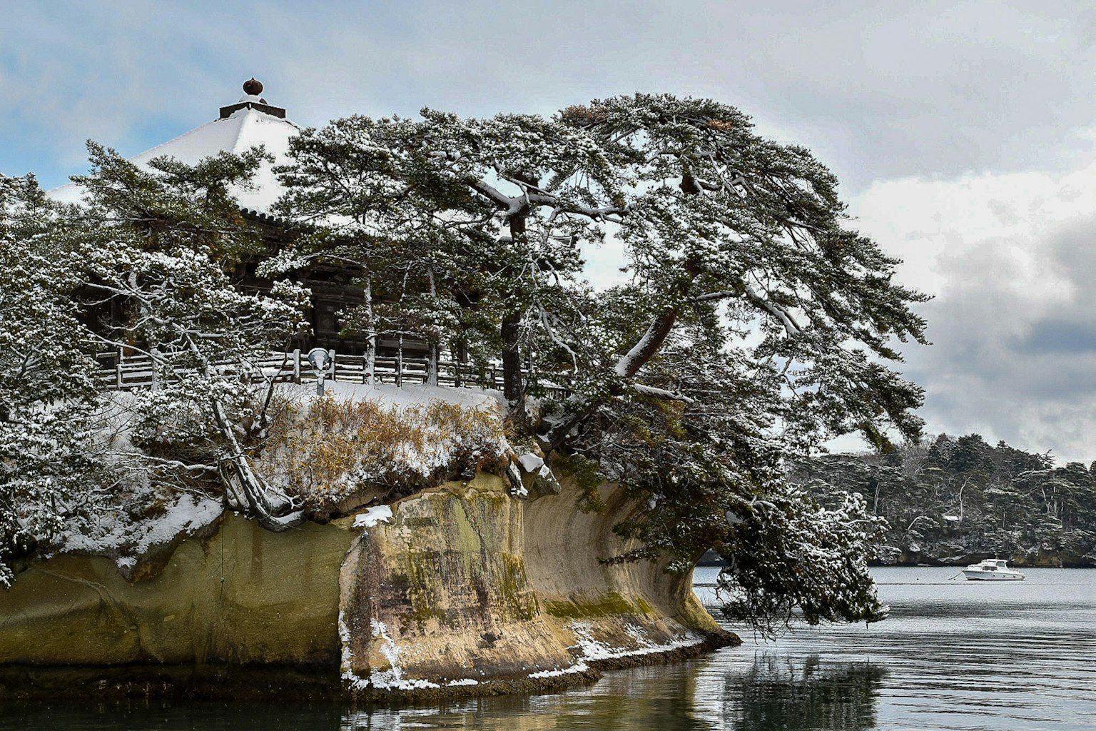 被雪覆盖的树木和水域环绕的传统建筑
