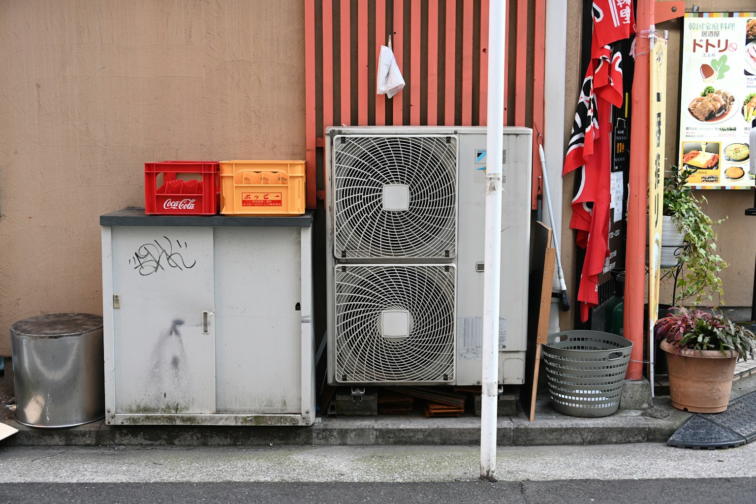 Klimaanlage und Aufbewahrungsschrank im Freien Rote Kisten und Pflanzen vorhanden