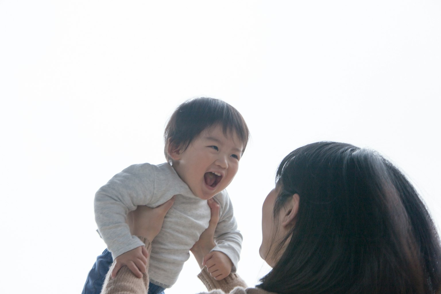 Lächelndes Baby, das von der Mutter gehalten wird