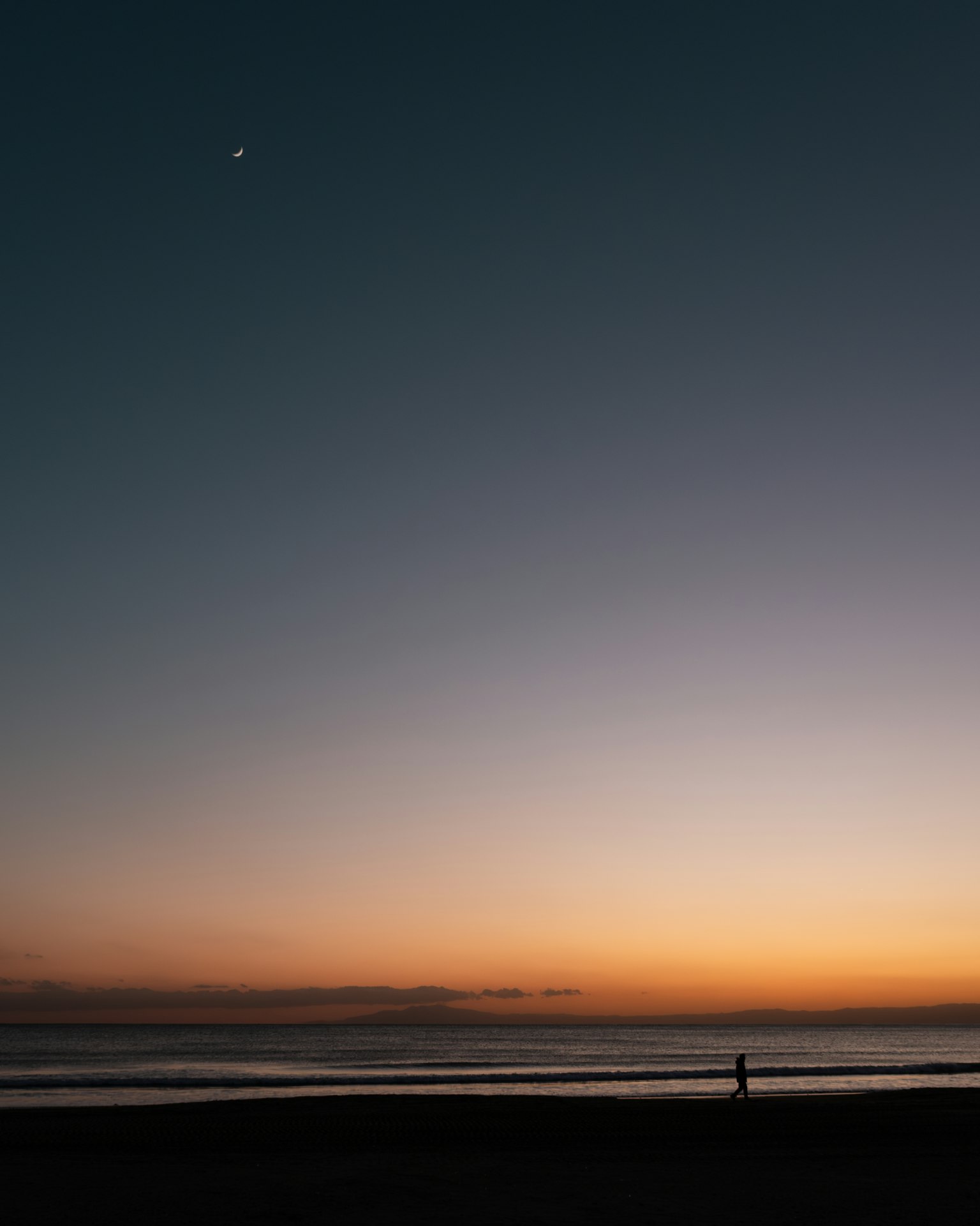 Une personne profitant d'un coucher de soleil sur une plage tranquille avec une étoile visible
