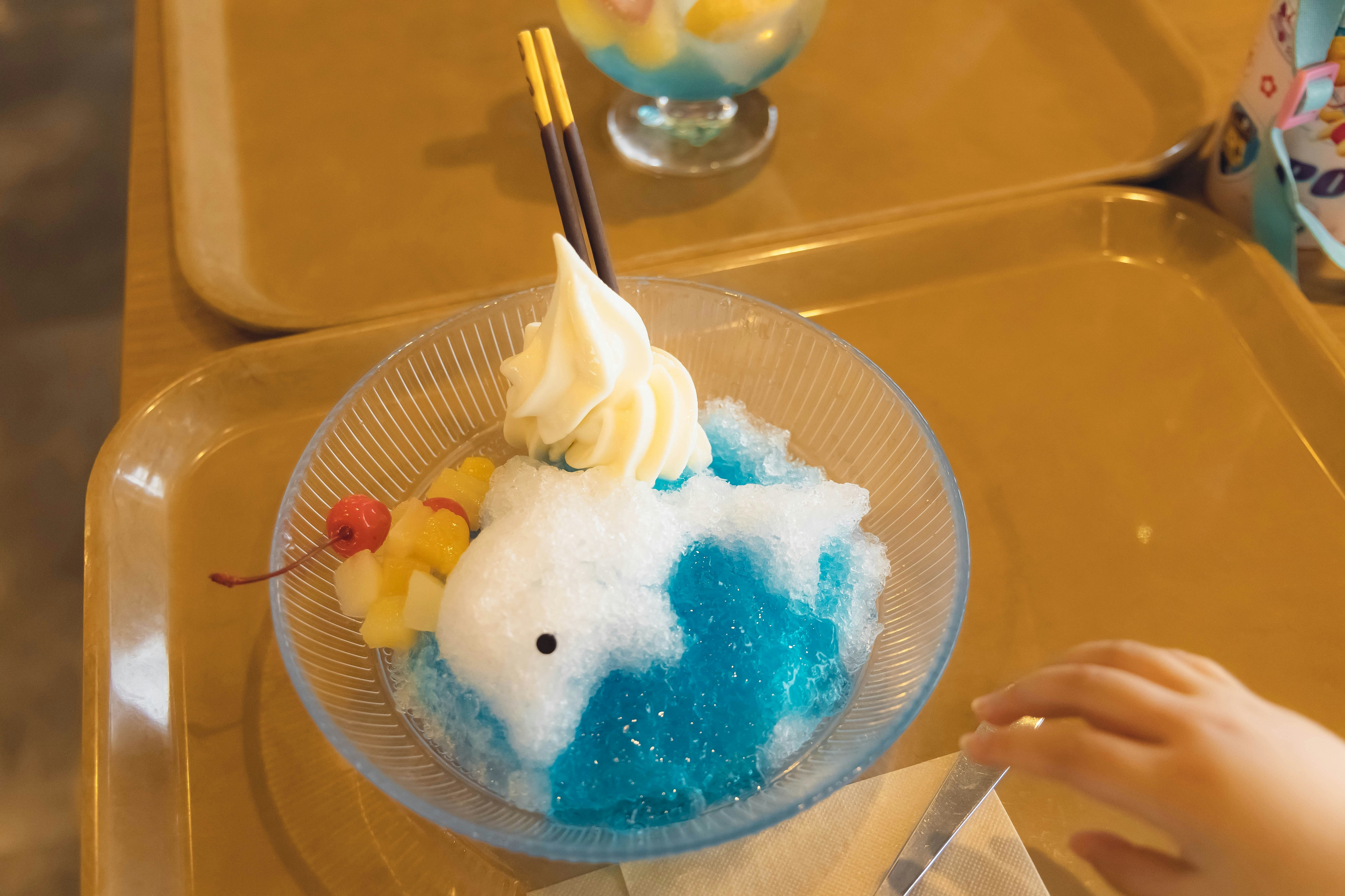 青いかき氷と白いふわふわの雪だるま風デザート