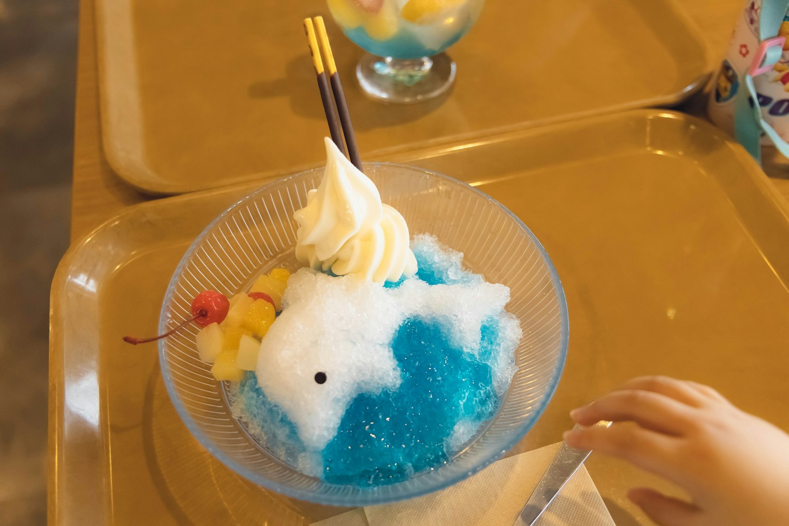 Un dessert con ghiaccio tritato blu guarnito con panna e frutta