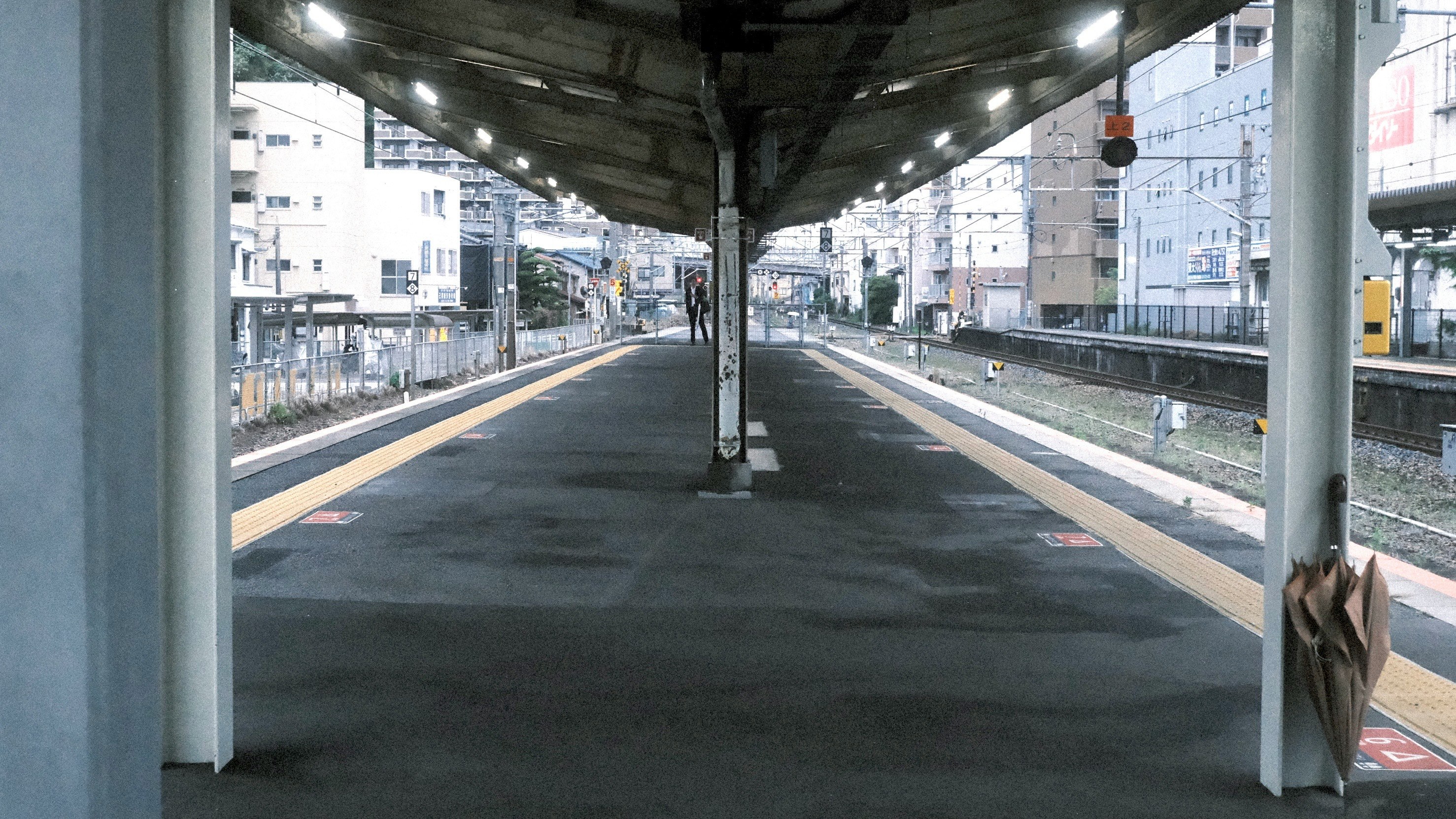高架下の無人ホームと線路が続く駅の通路