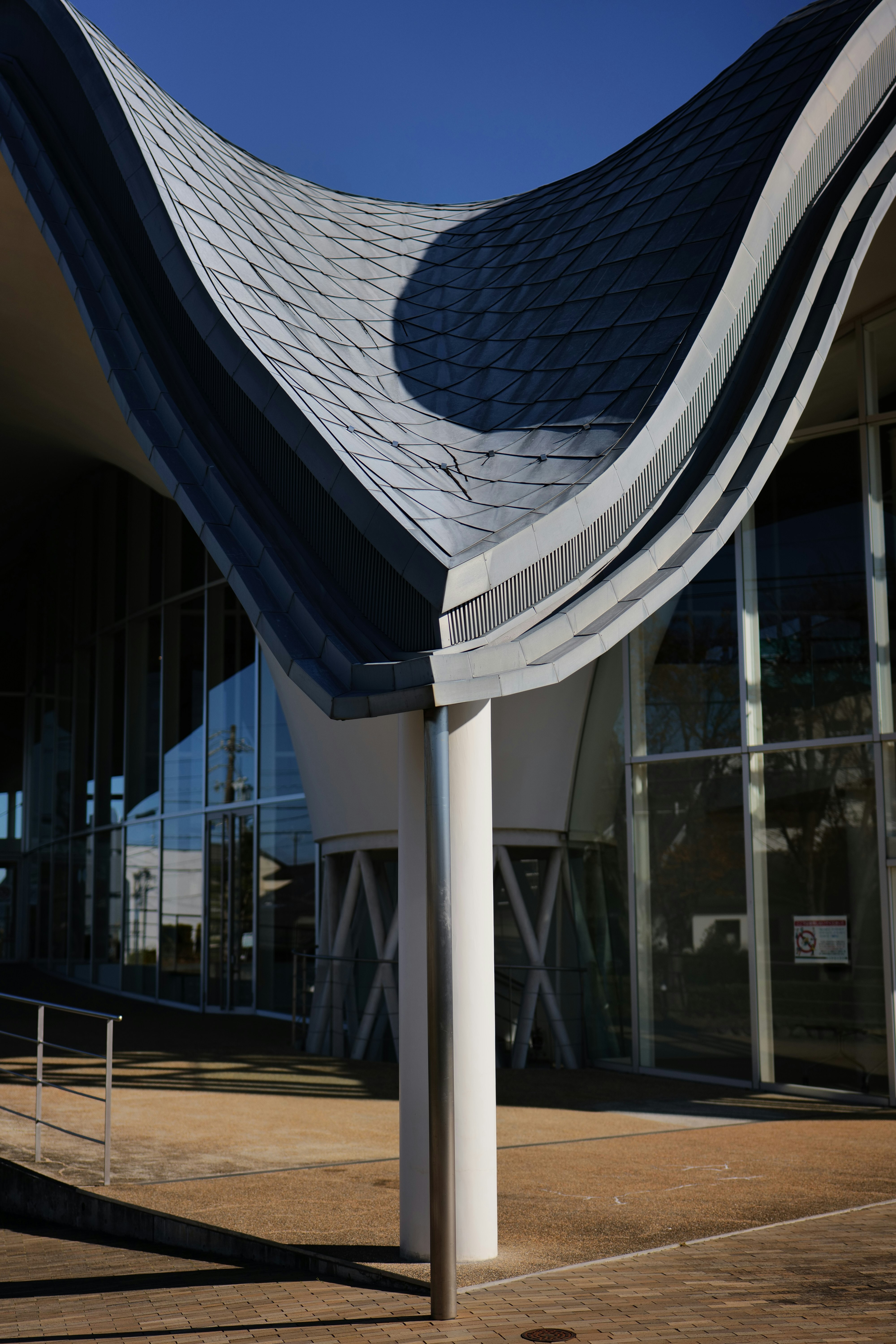 modern exterior with curved roof and glass facade