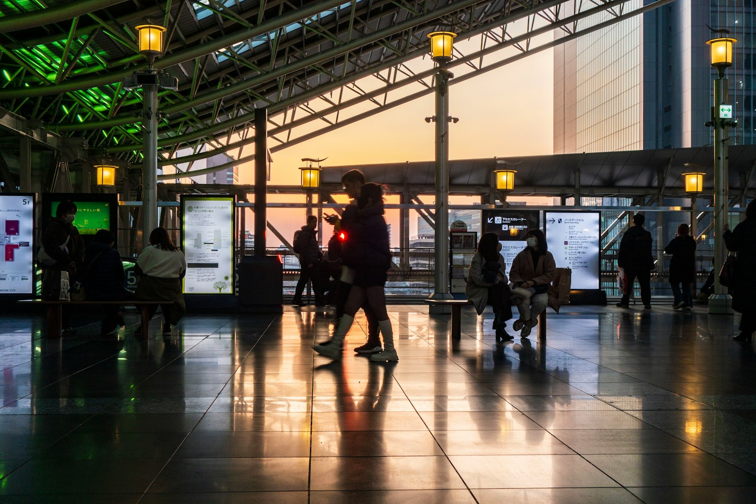 Vue intérieure d'une station avec des gens marchant au coucher du soleil