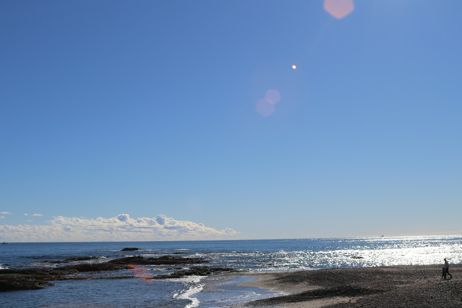 ทิวทัศน์ชายหาดที่มีท้องฟ้าสีฟ้าใสและทะเลสงบ