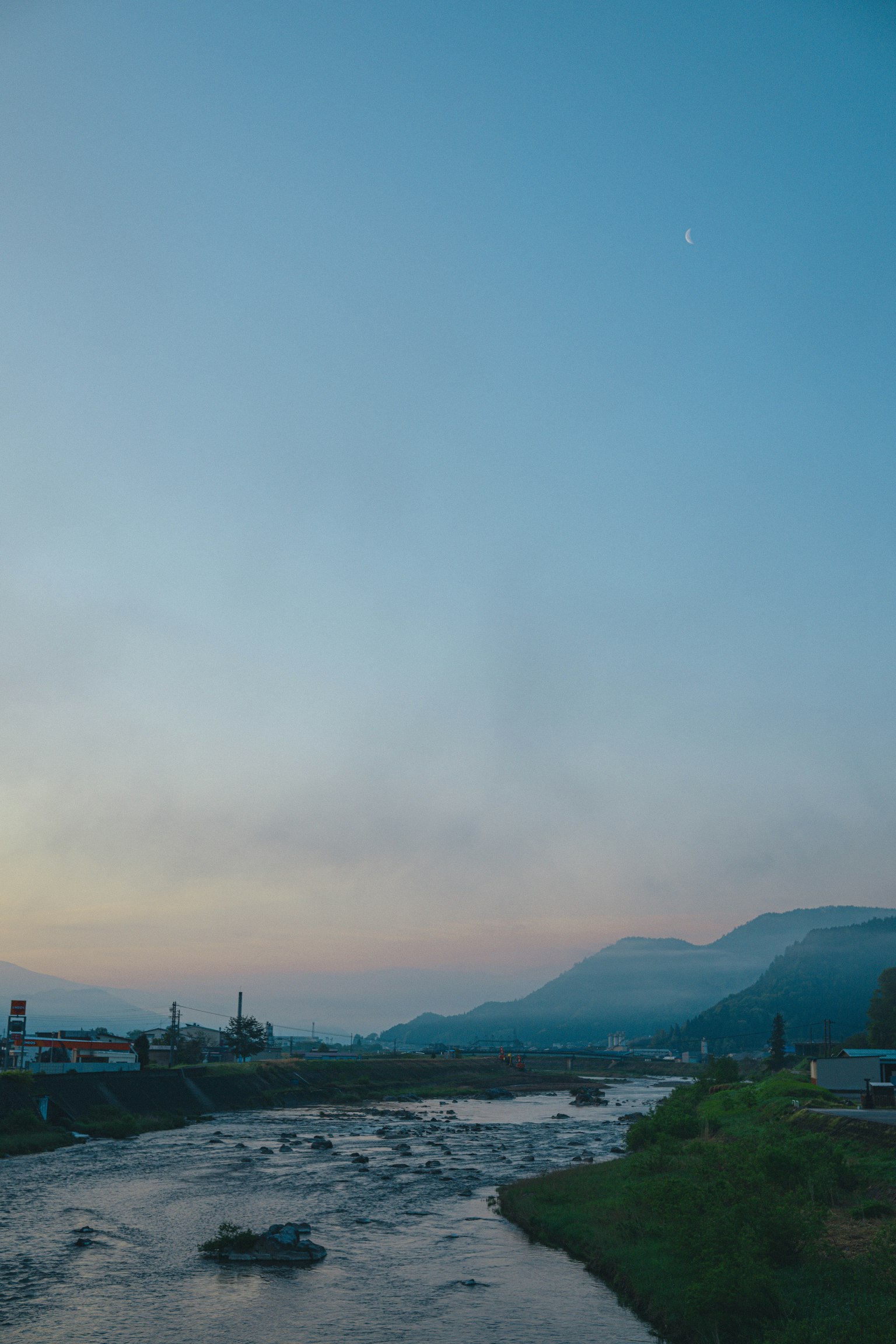 Un paesaggio sereno con un fiume e montagne al crepuscolo