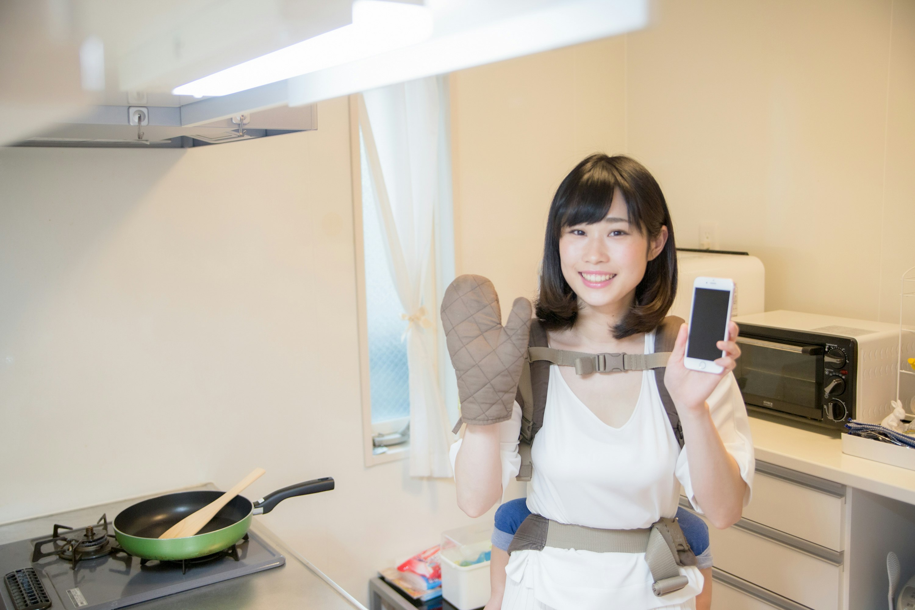 廚房裡拿著手機的女性