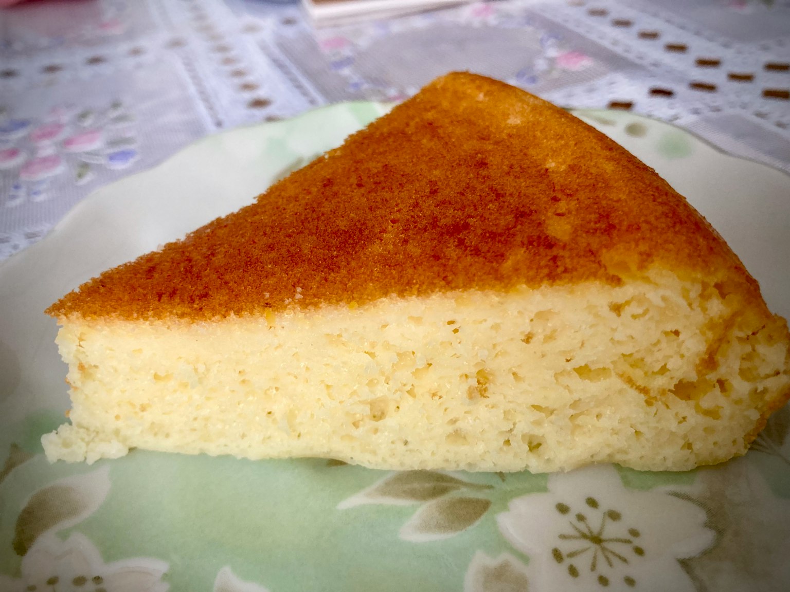 Ein Stück fluffiger Käsekuchen auf einem weißen Teller