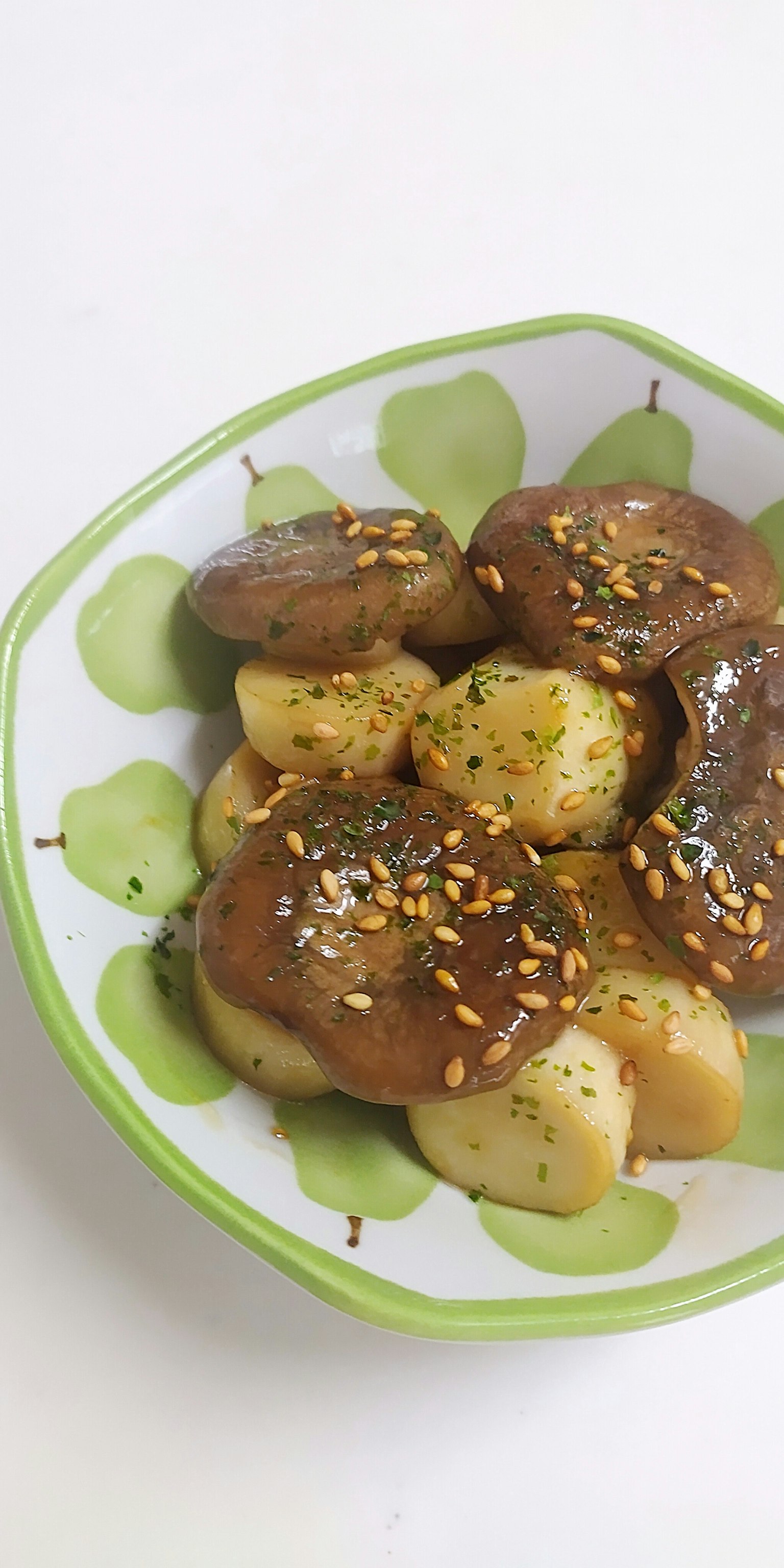 Gericht aus Kartoffeln und Pilzen in einer Schüssel mit grünem Rand serviert