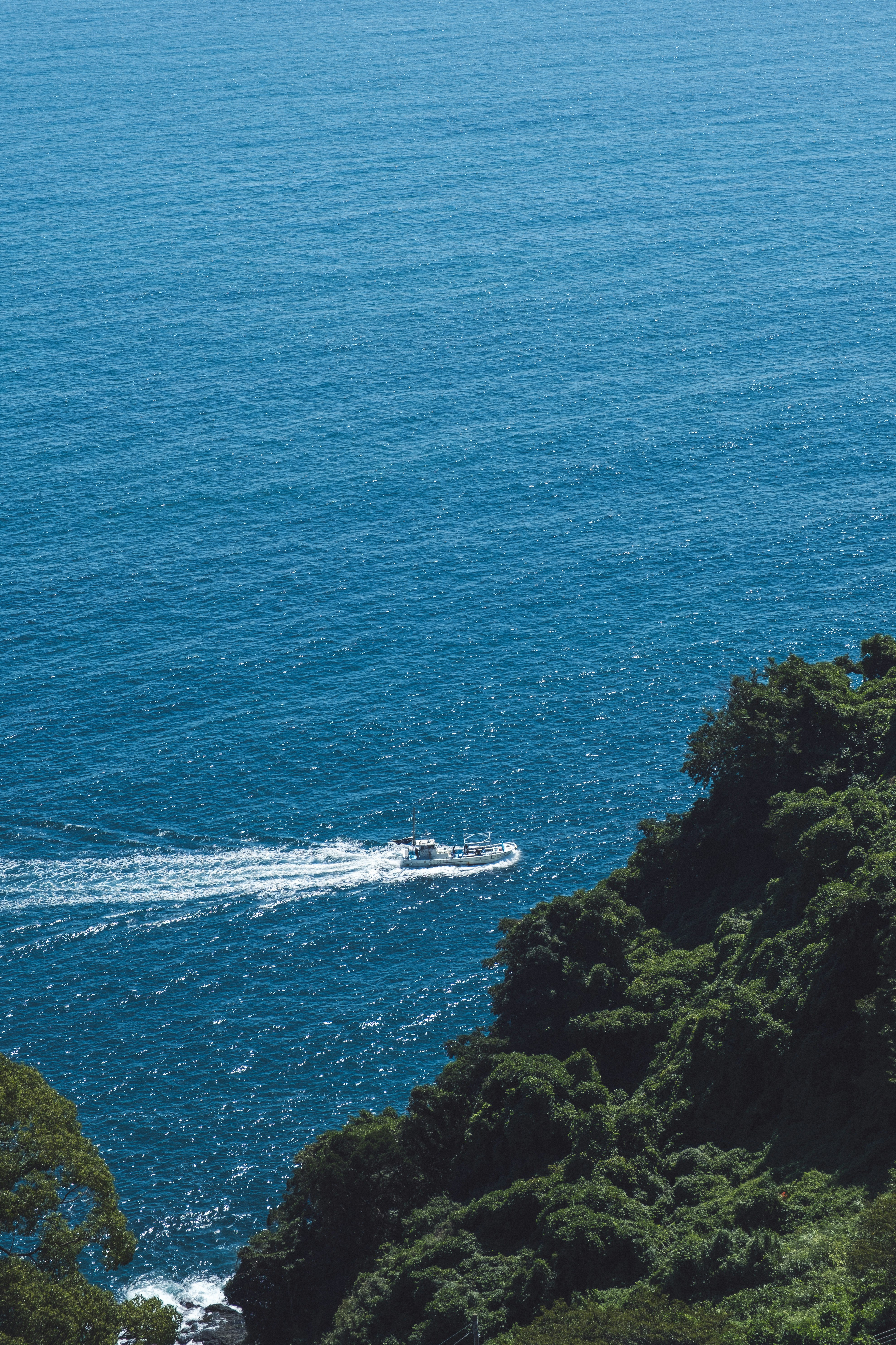 熱海の海を見下ろす断崖と小舟のある海景