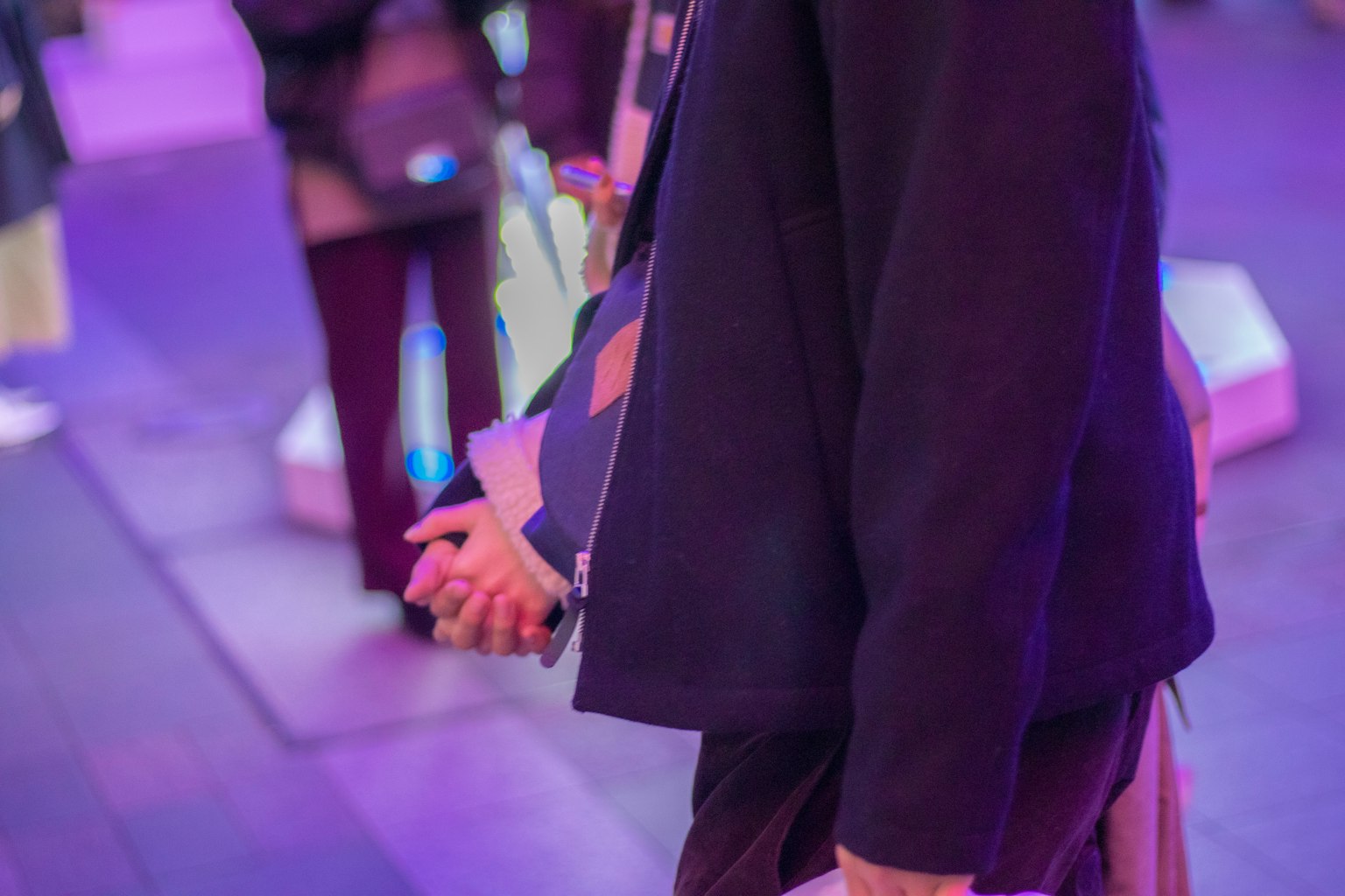 Couple holding hands in profile with purple lighting