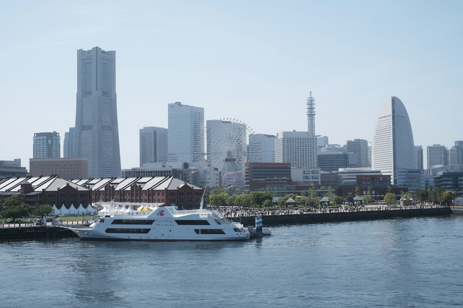 Yacht bianco a Yokohama con skyline moderno e lungomare