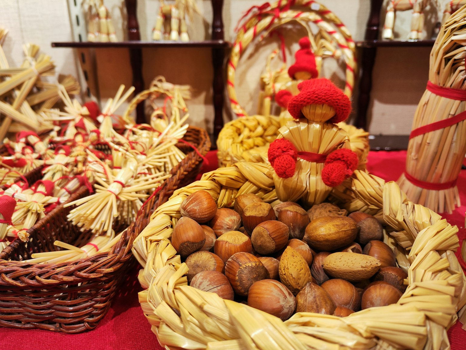 Una mostra vivace con un cesto di paglia pieno di noci e figure decorative di paglia
