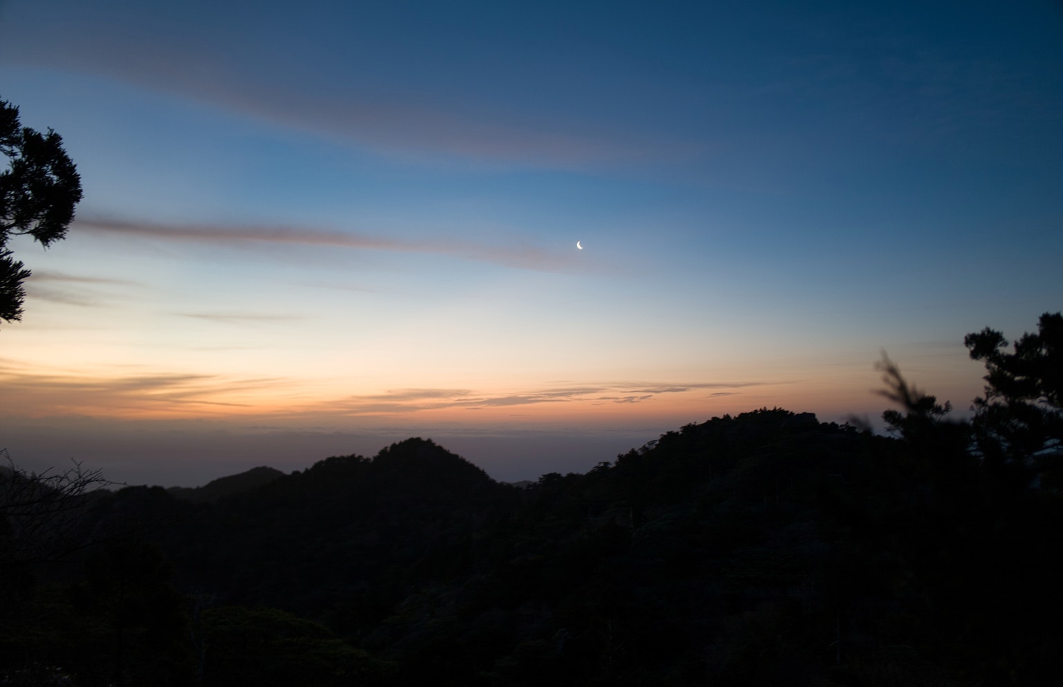 Scenic view of a sunset with silhouettes of mountains