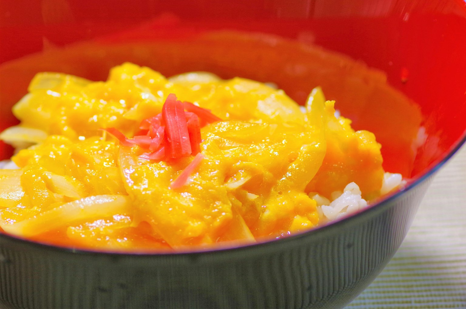 Estofado de calabaza servido sobre arroz blanco en un tazón rojo