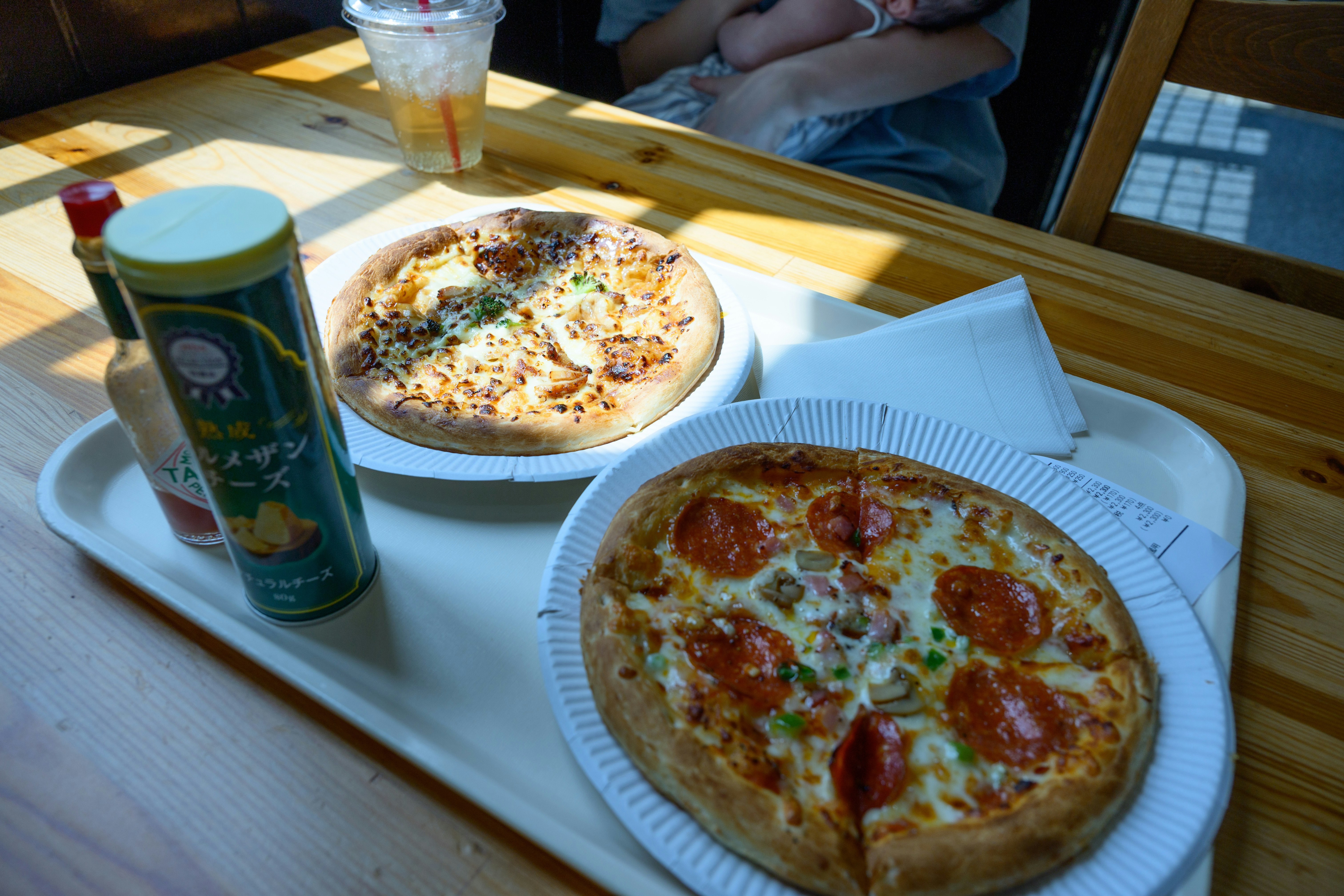 テーブルに並ぶピザと飲み物の食事風景