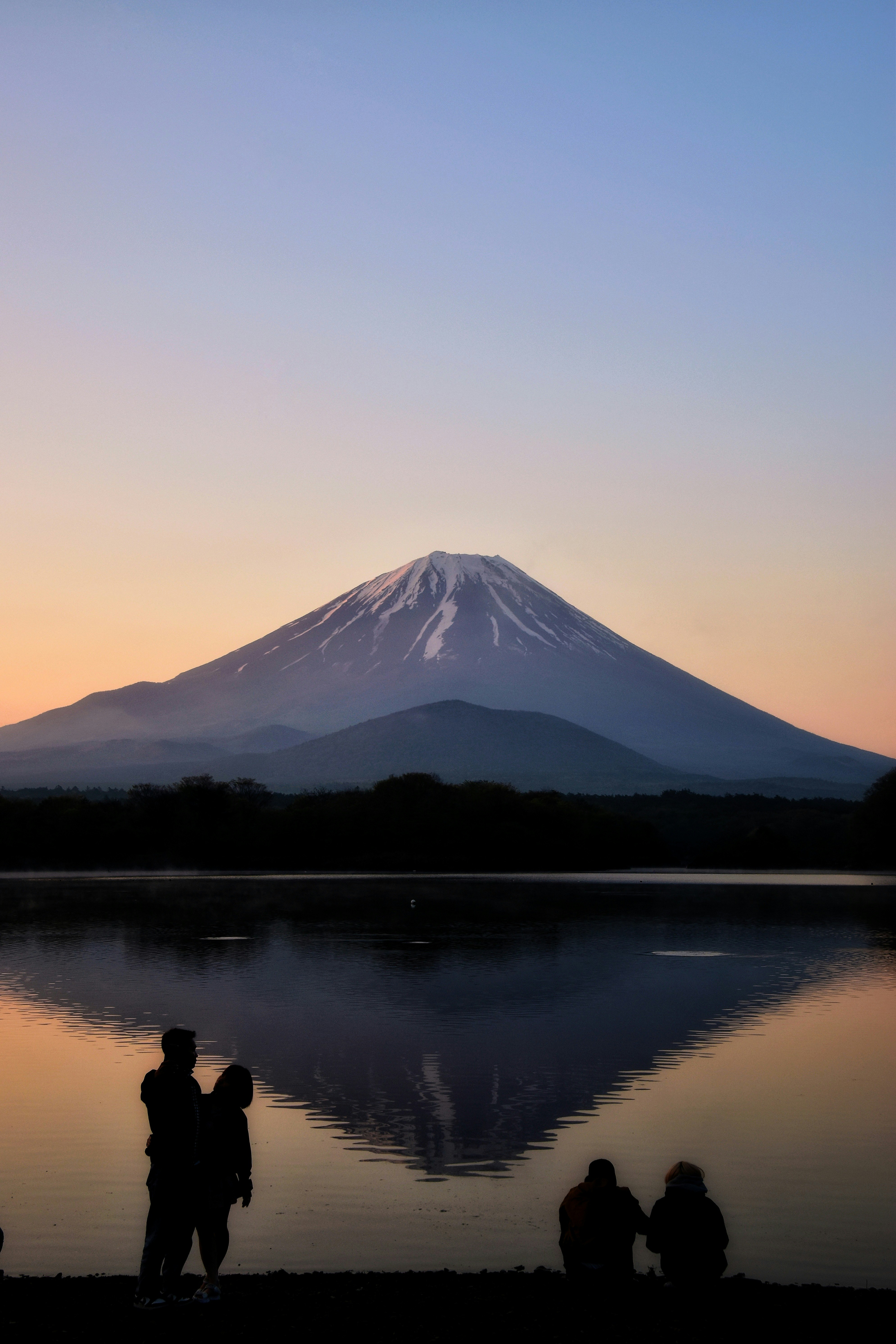 精進湖の夜明けに浮かぶ富士山と湖面の静けさ