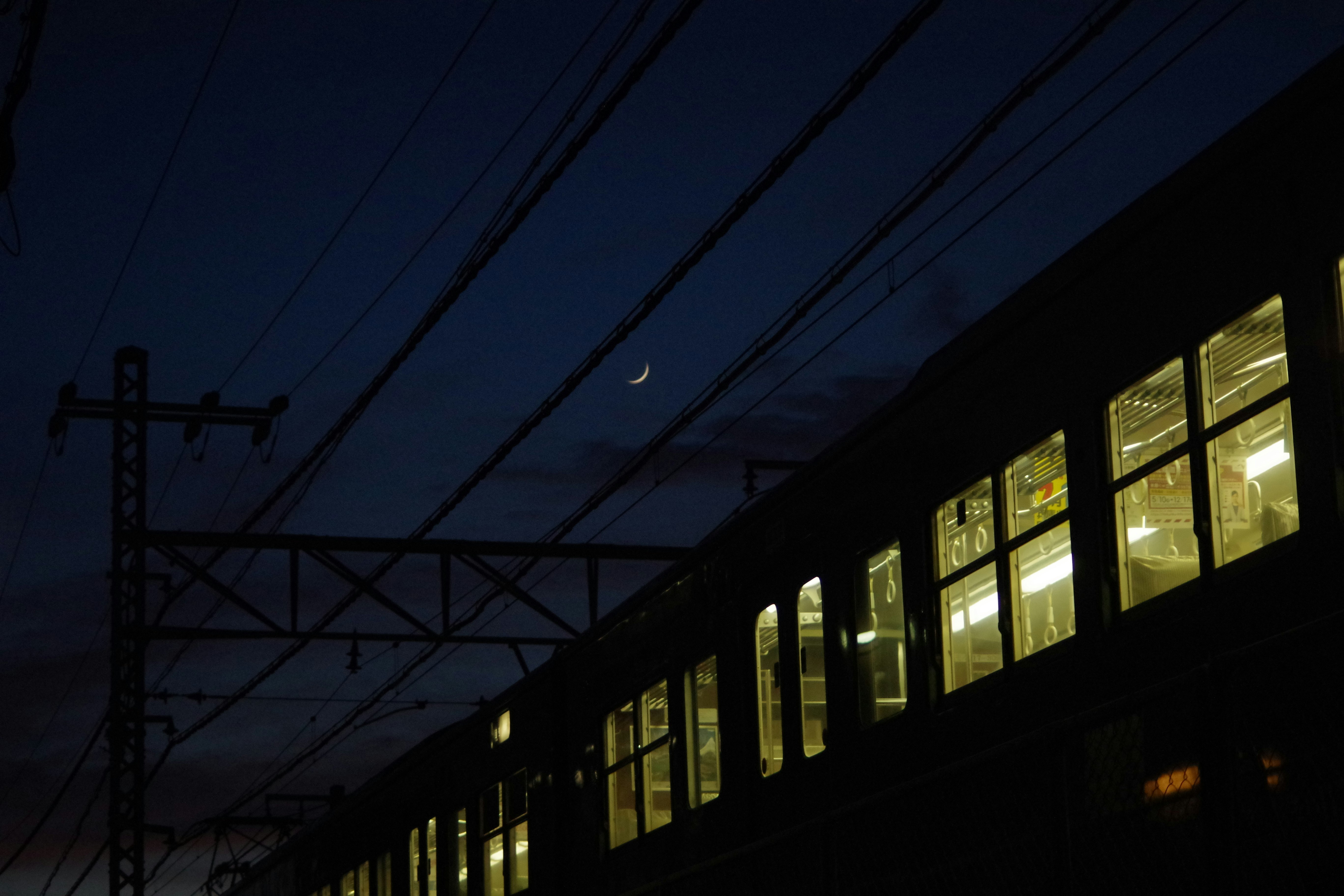 夜の電車が走る線路沿いの街並み