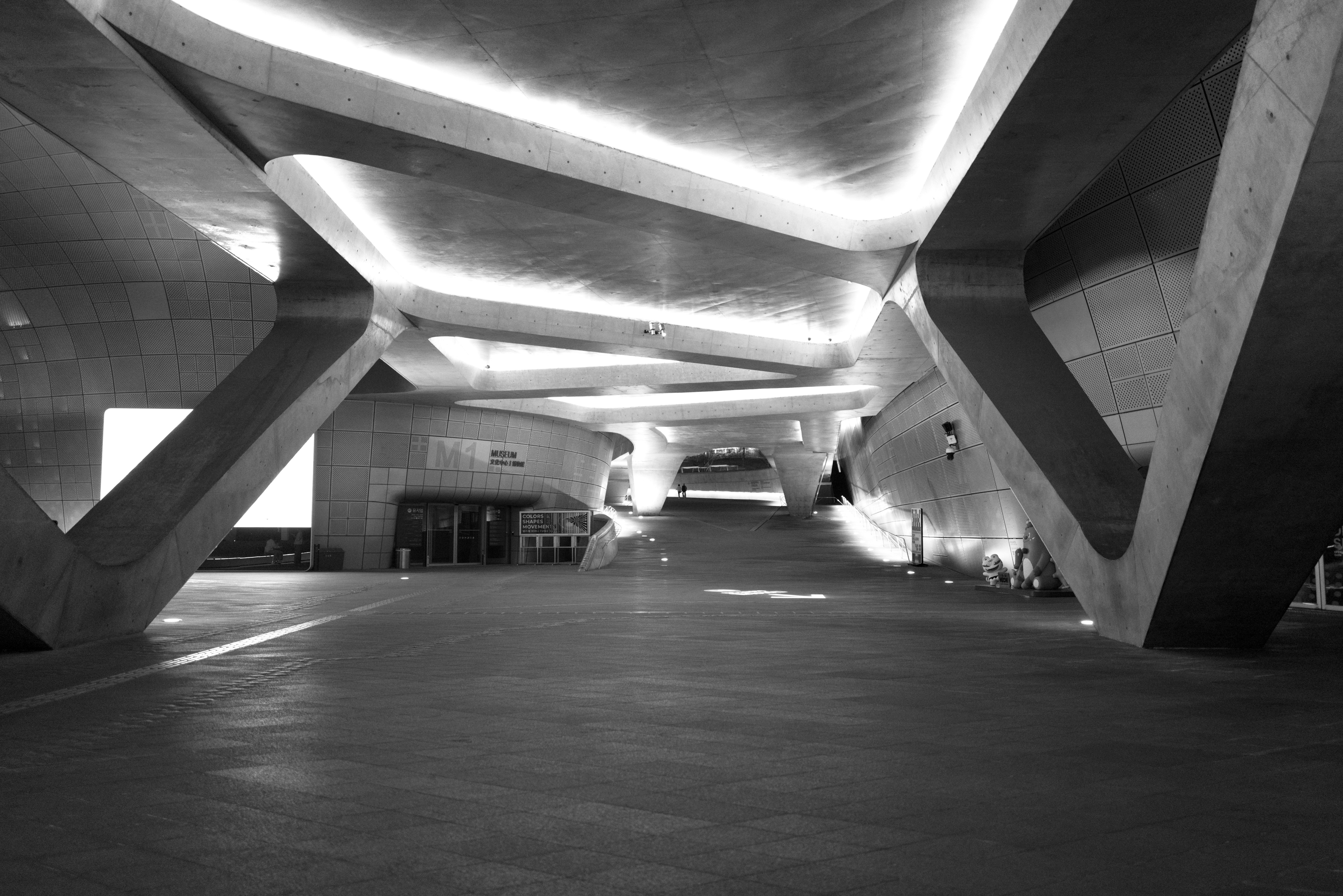 vista nocturna en blanco y negro de un paso subterráneo de hormigón con vigas radiales