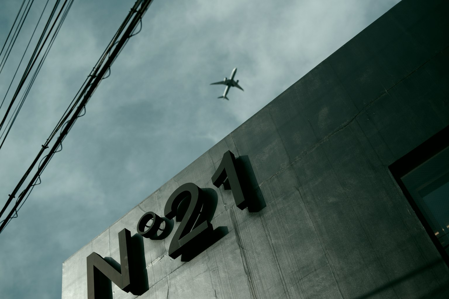 Close-up of N21 building with an airplane flying overhead