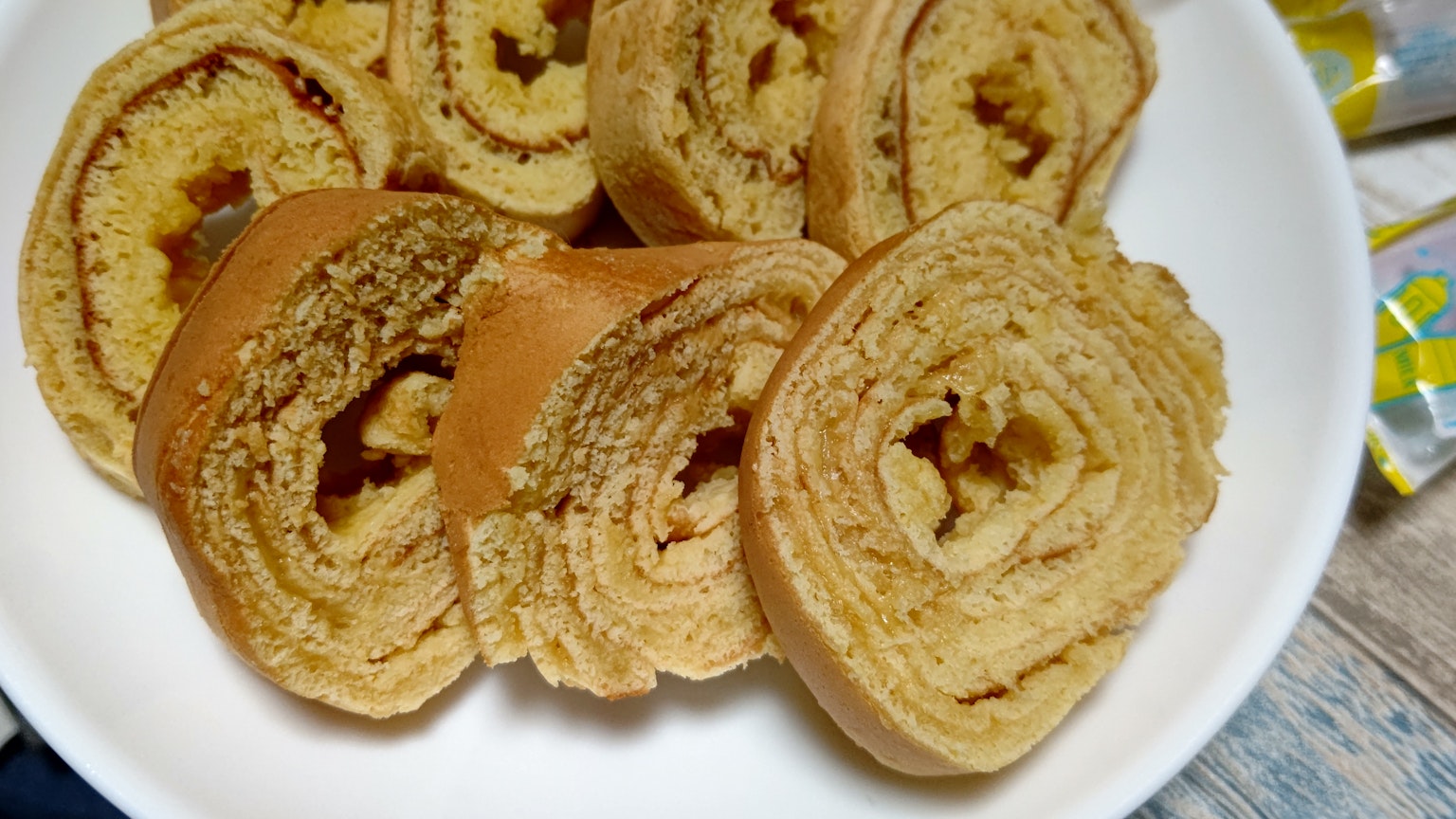 Torta arrotolata affettata su un piatto bianco che mostra i suoi strati a spirale