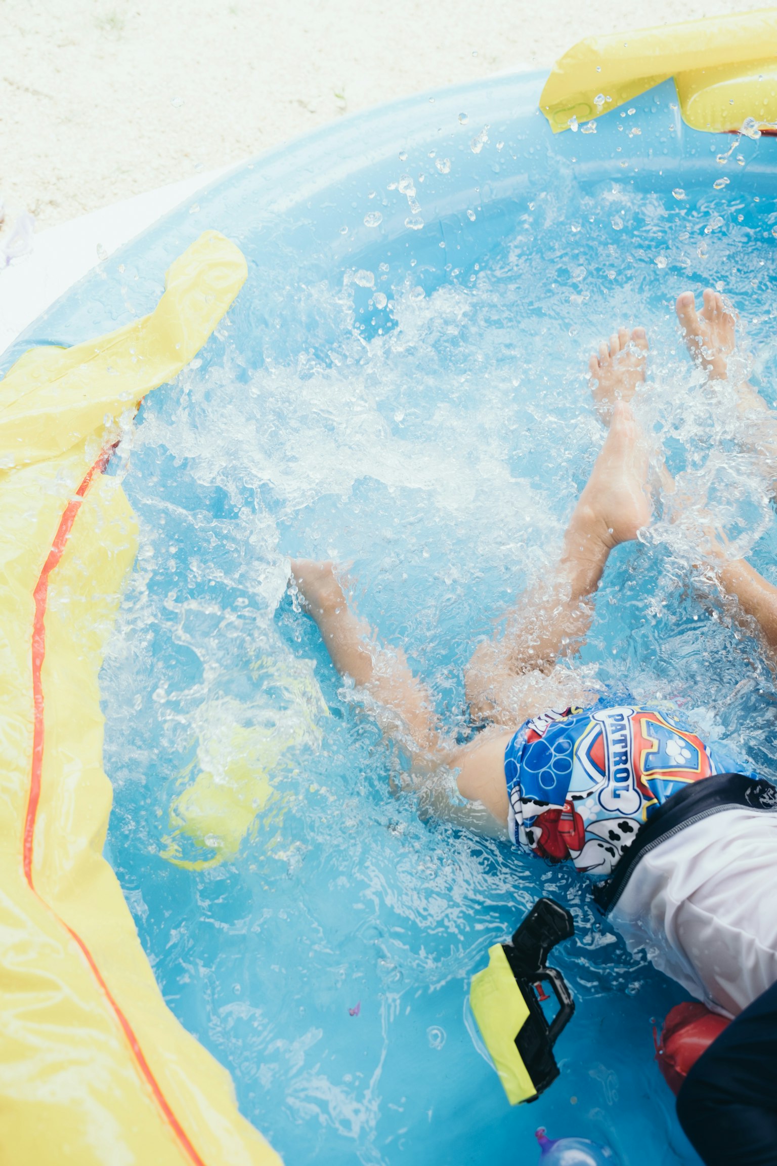 Anak bermain di kolam renang memercikkan air