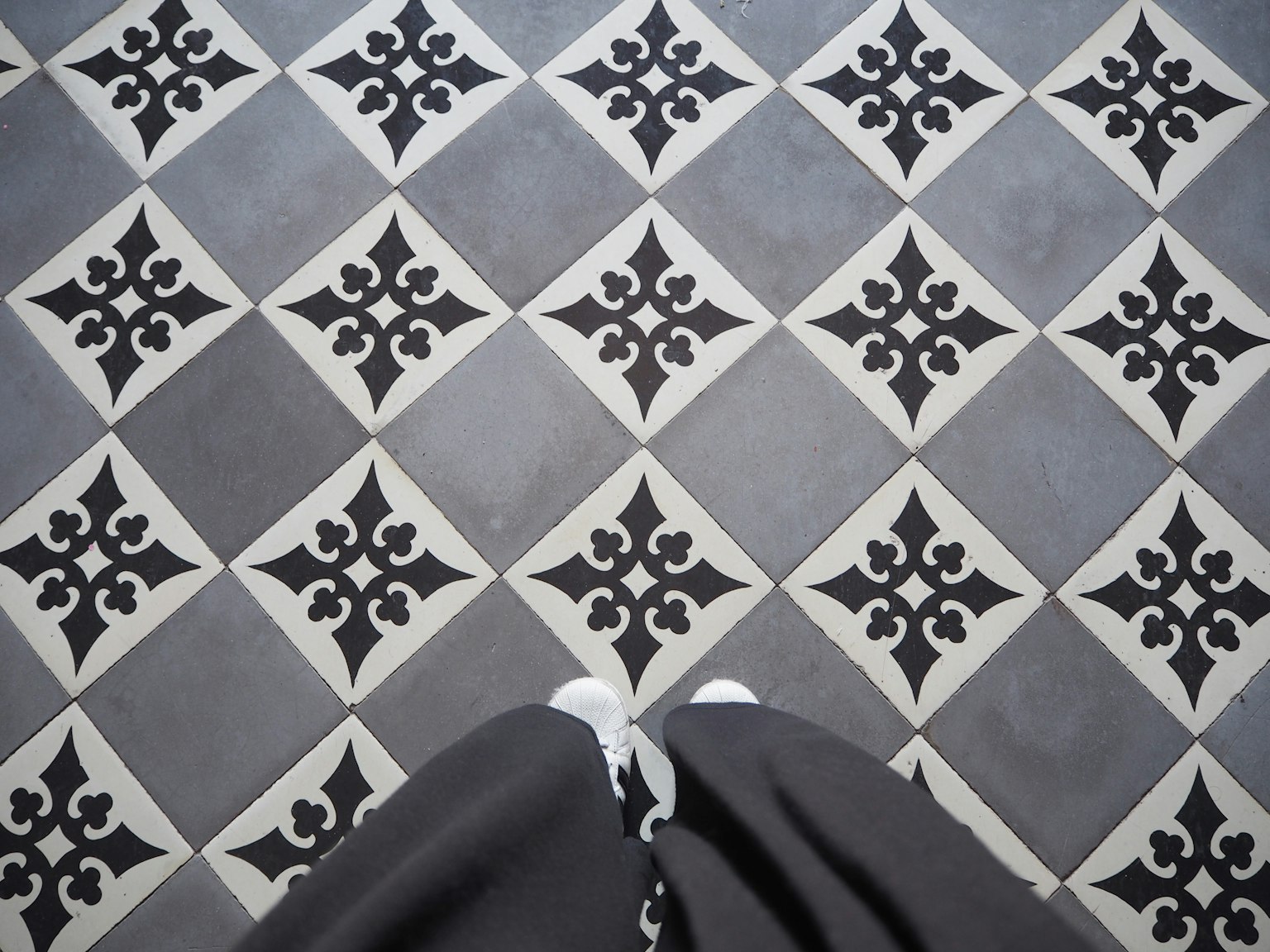 Monochrome tile pattern with feet in black clothing