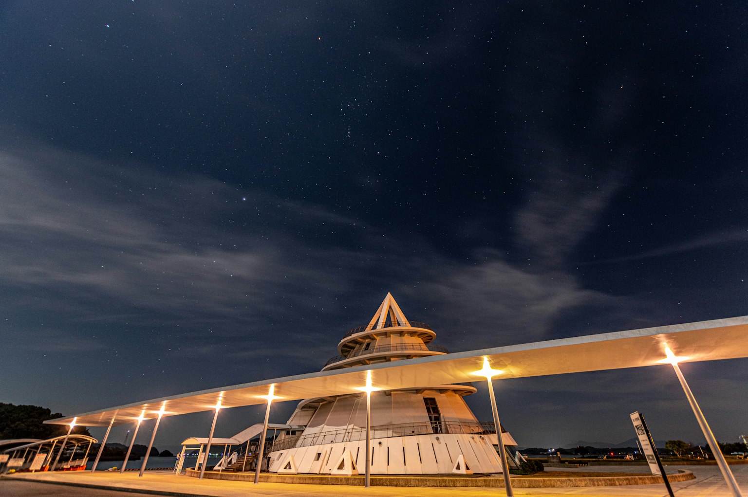 Structure architecturale unique illuminée la nuit sous un ciel étoilé