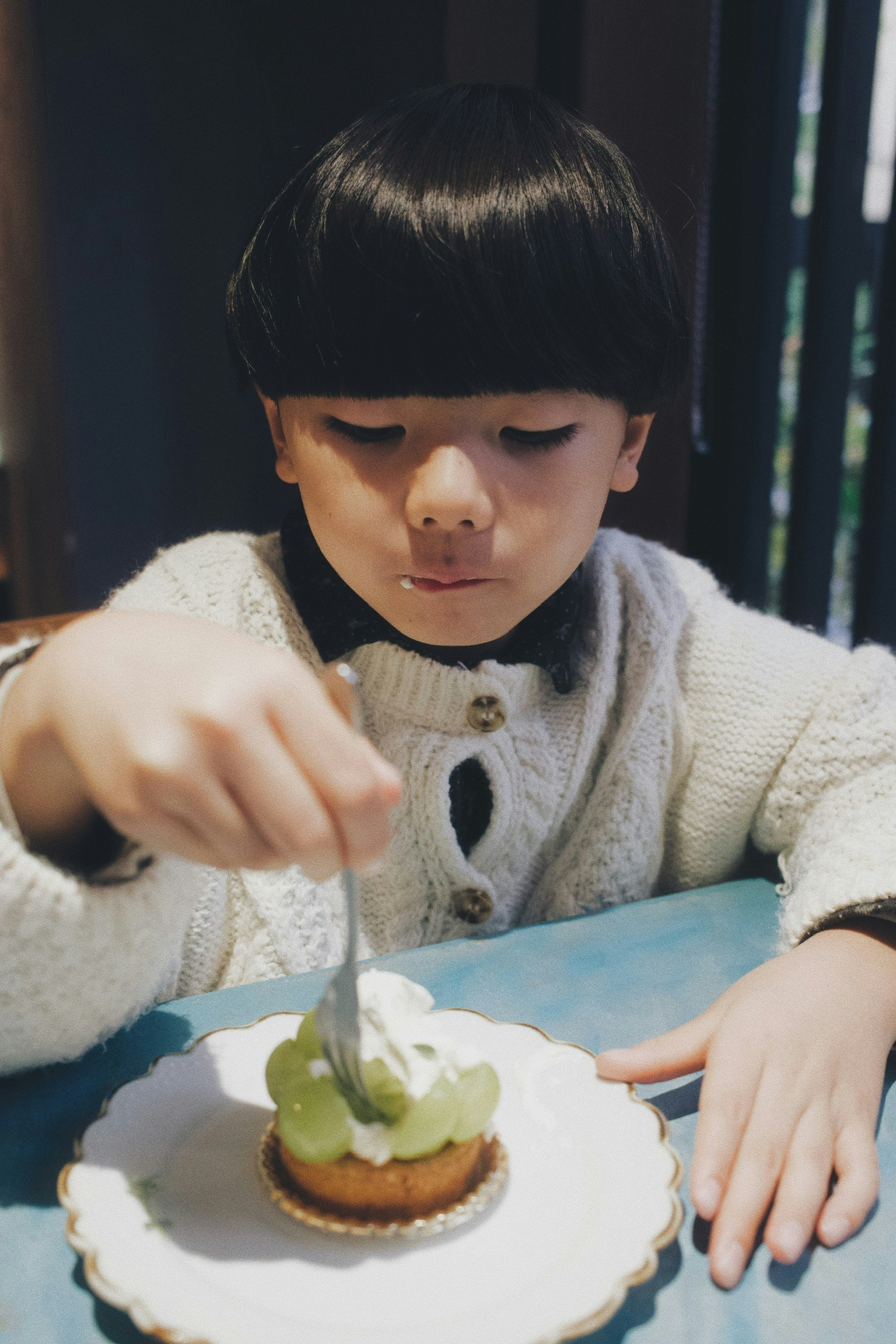 孩子在家庭餐桌上伸手拿蛋糕