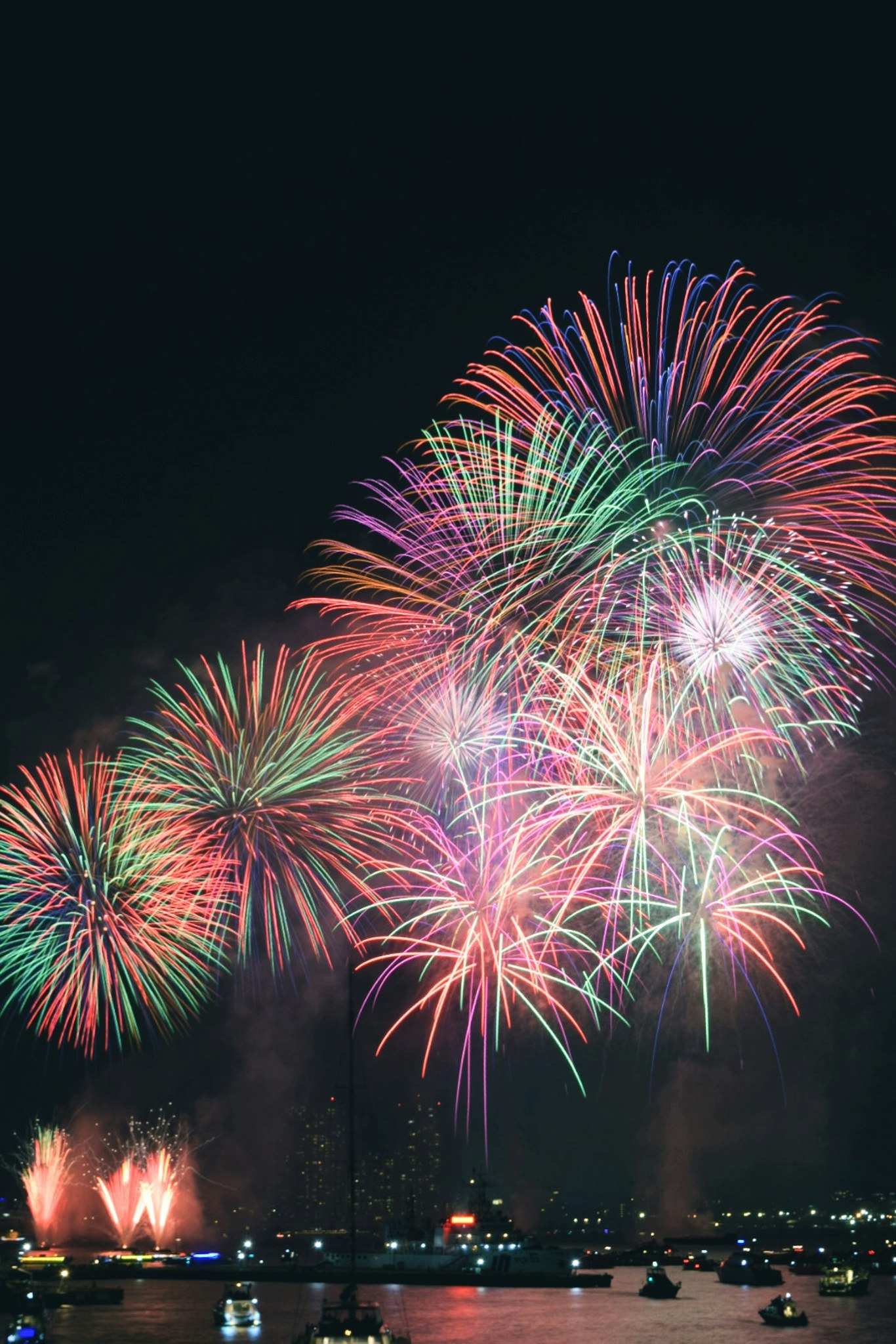 夜空中绽放的五彩烟花与滨水灯光